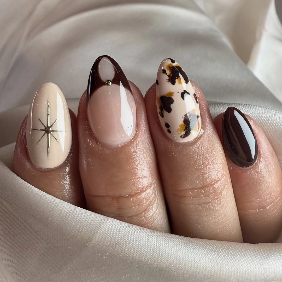 Nude almond nails with brown French tips cow print and starburst