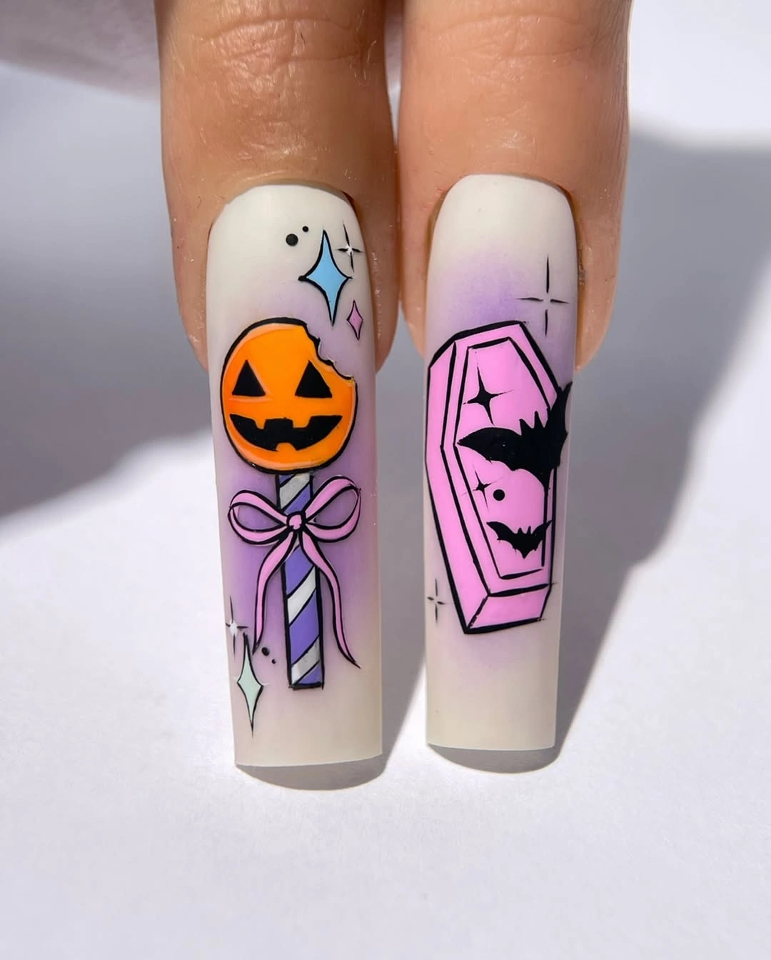 Long cream square nails with pink coffin pumpkin bat and bow art