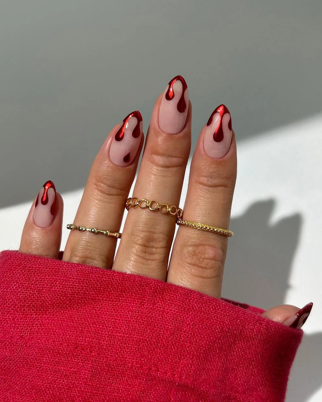 Nude almond nails with deep red drip tips