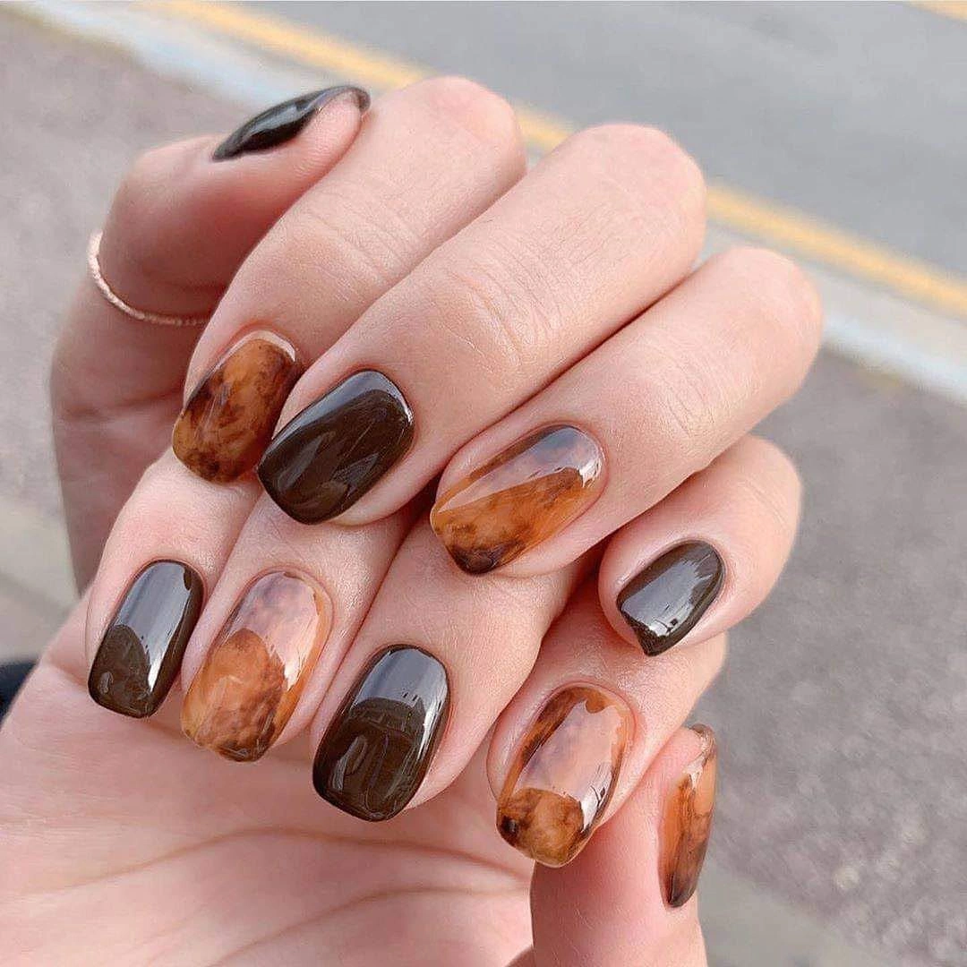 Short rounded nails with brown cream and gray marbled swirls