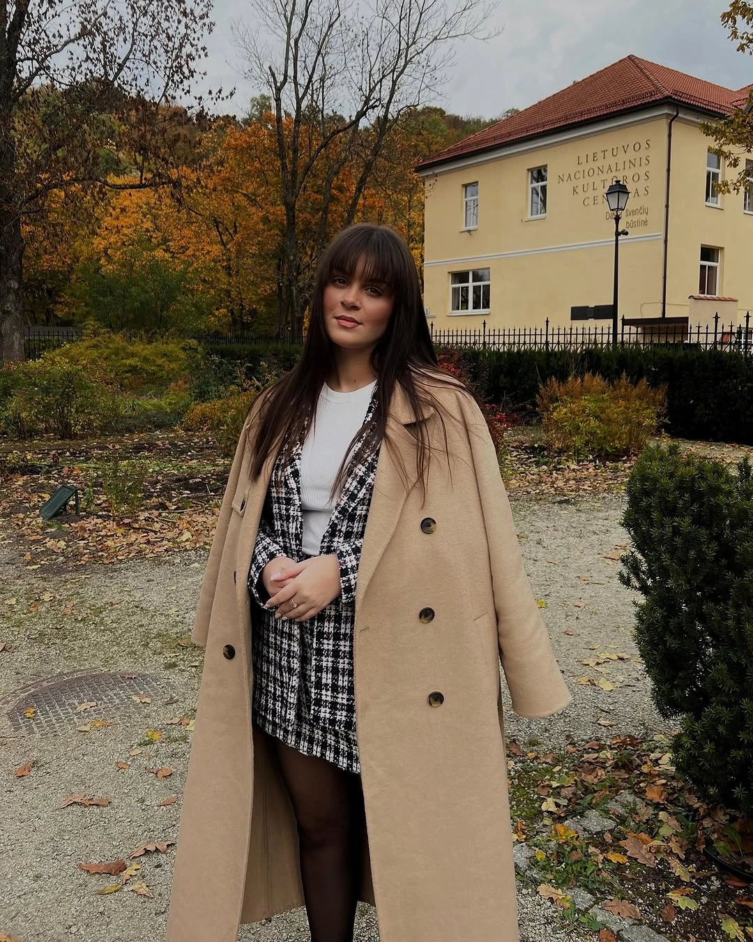 Camel coat over black and cream checked short outfit
