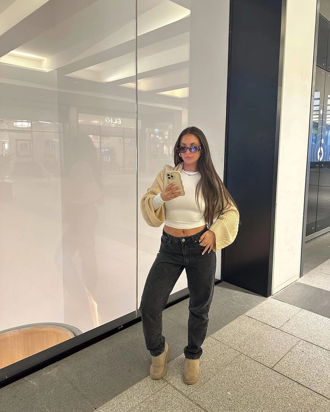 Cream cropped knit with black jeans tan jacket and ankle boots