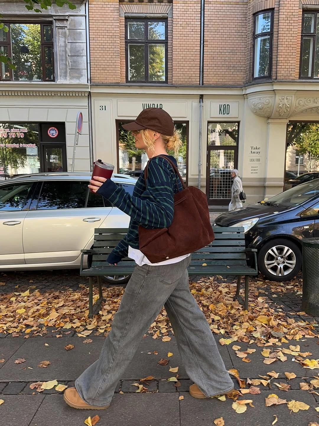 Brown cap with green plaid overshirt gray loose trousers and large bag