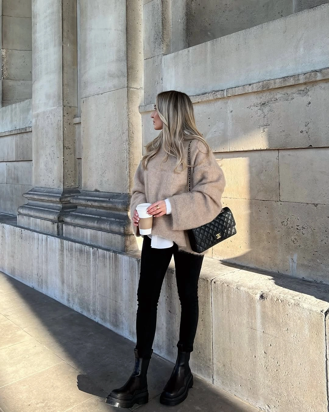 Beige fuzzy jacket with black trousers and chunky boots