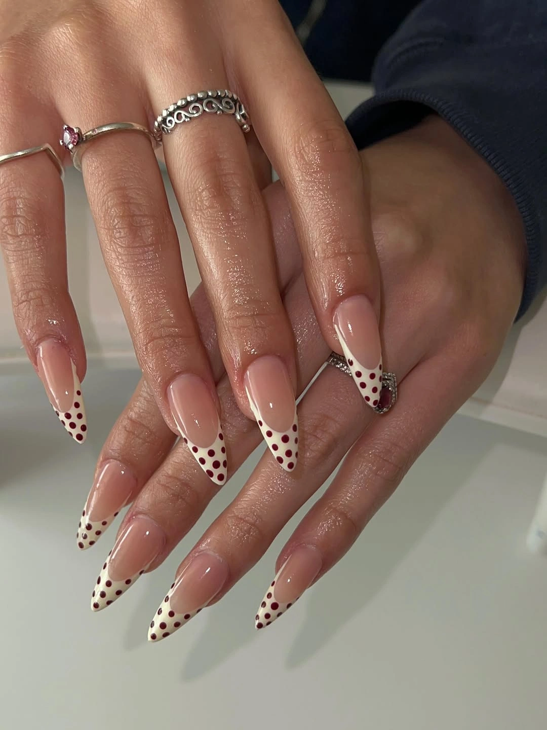 Long nude stiletto nails with white black spotted French tips