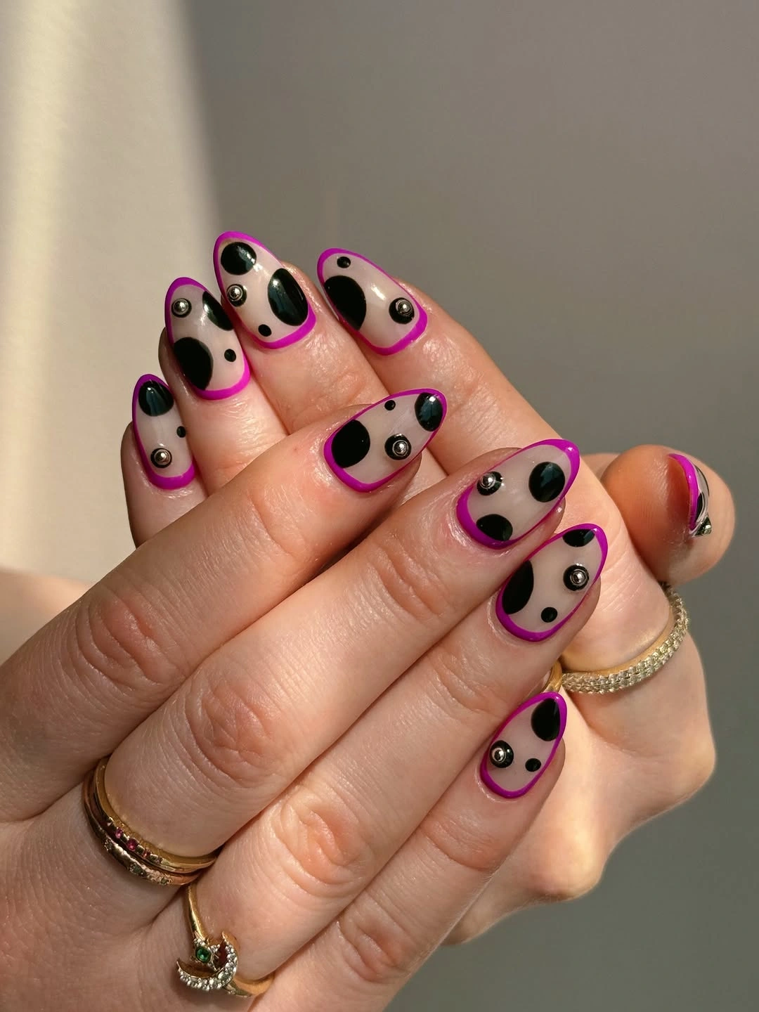 Nude oval nails with black dots and vivid pink French arcs