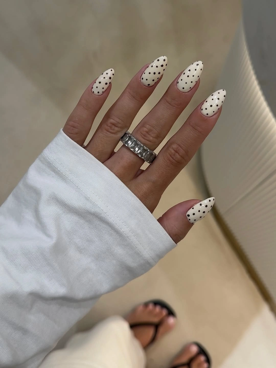 Long off white almond nails with fine scattered black dots