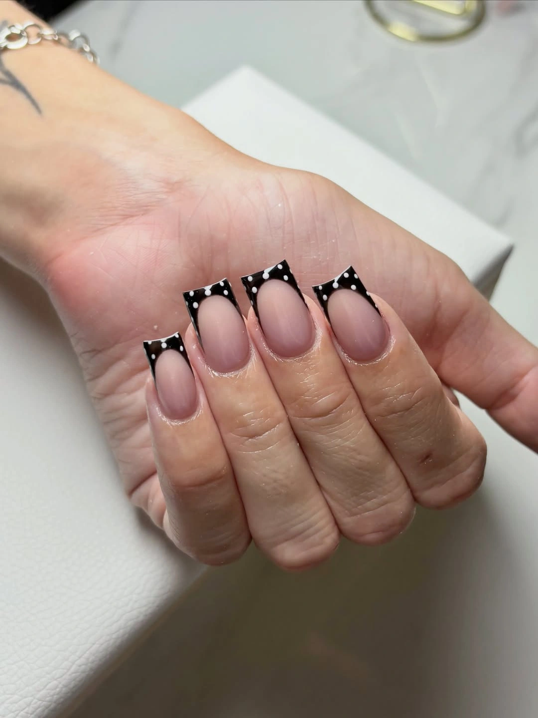 Nude square nails with black French corners and white dots