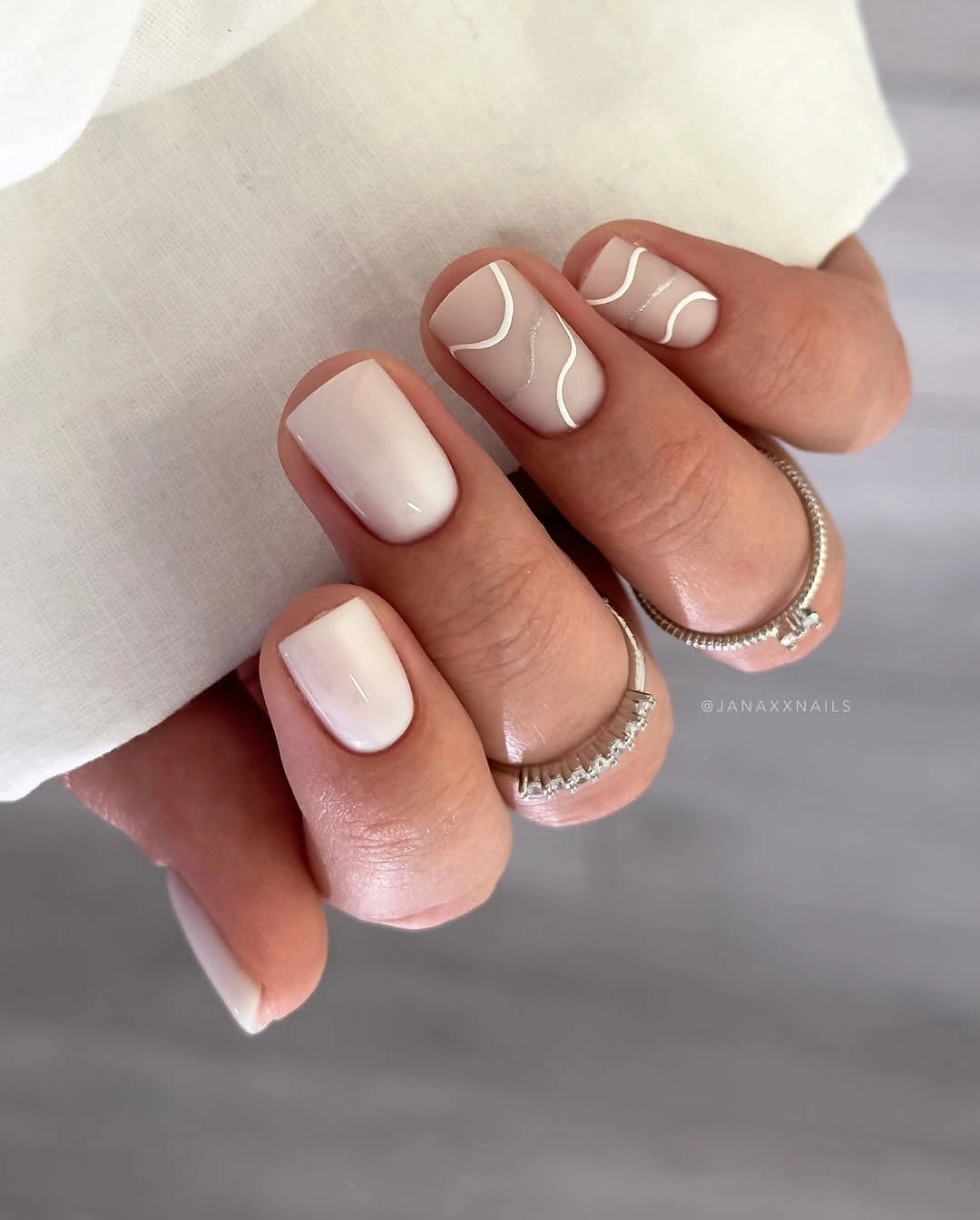 Short creamy nails with thin white wavy lines