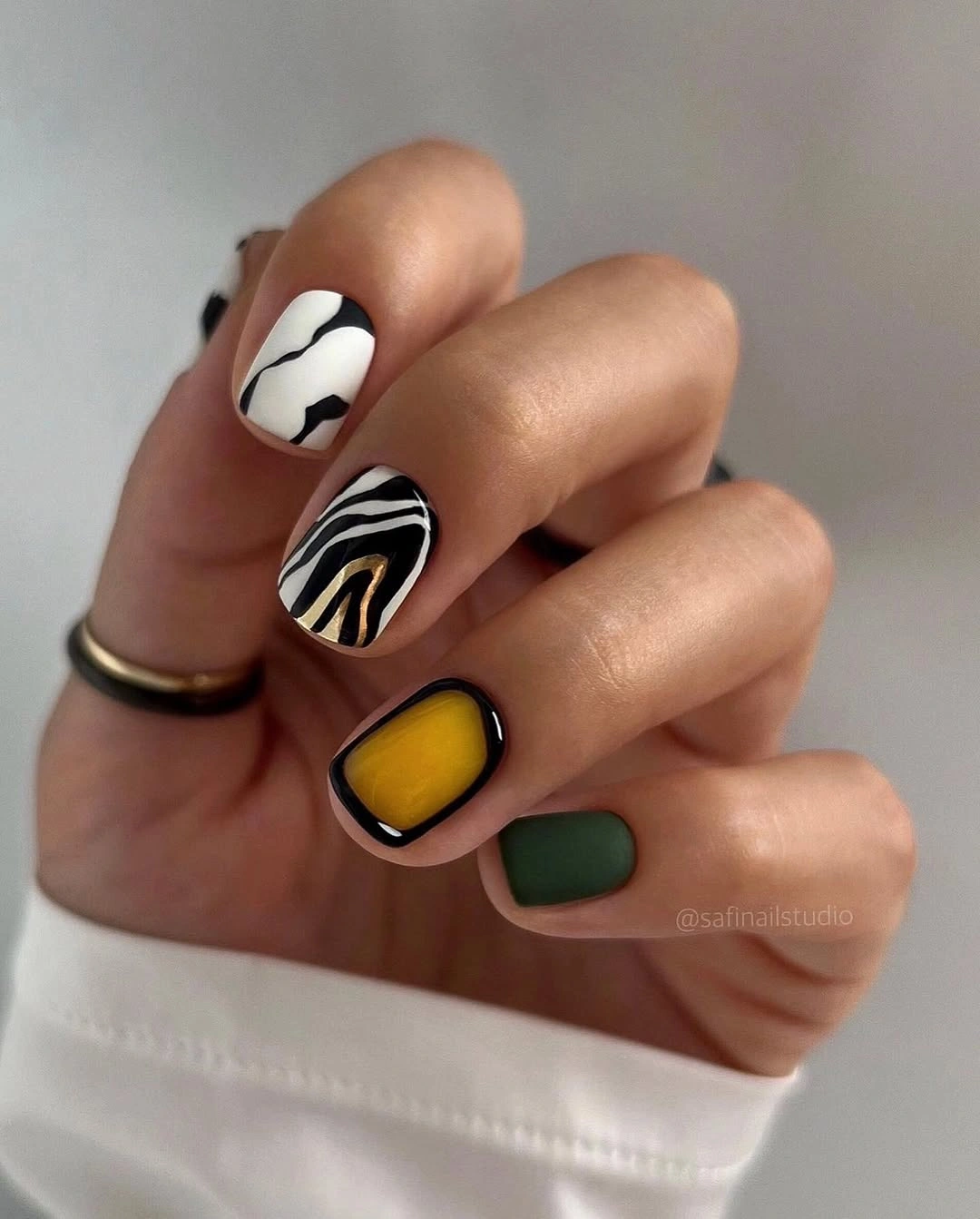 Short geometric nails with black white yellow and green blocks