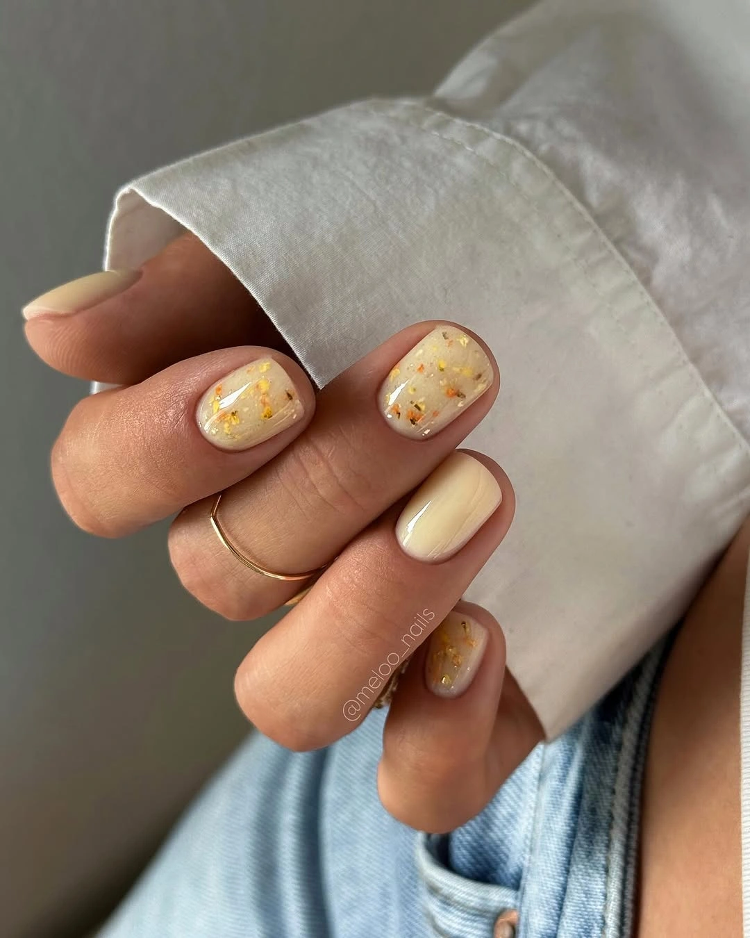 Short cream nails with tiny yellow orange speckles