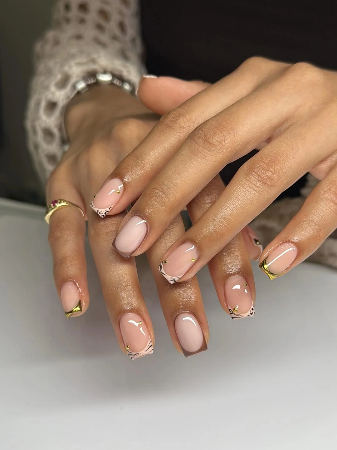 Short nude nails with delicate French edges and tiny details