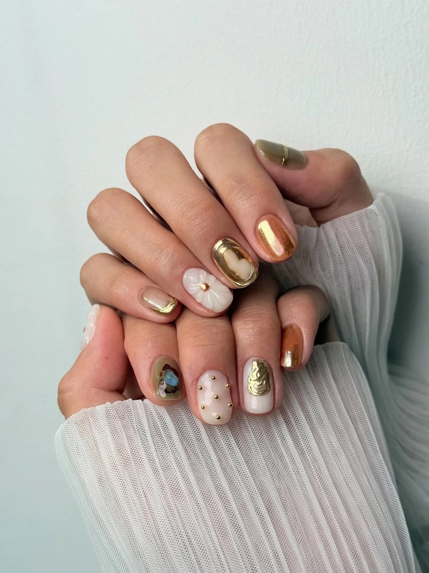 Short neutral nails with gold white and tiny accents