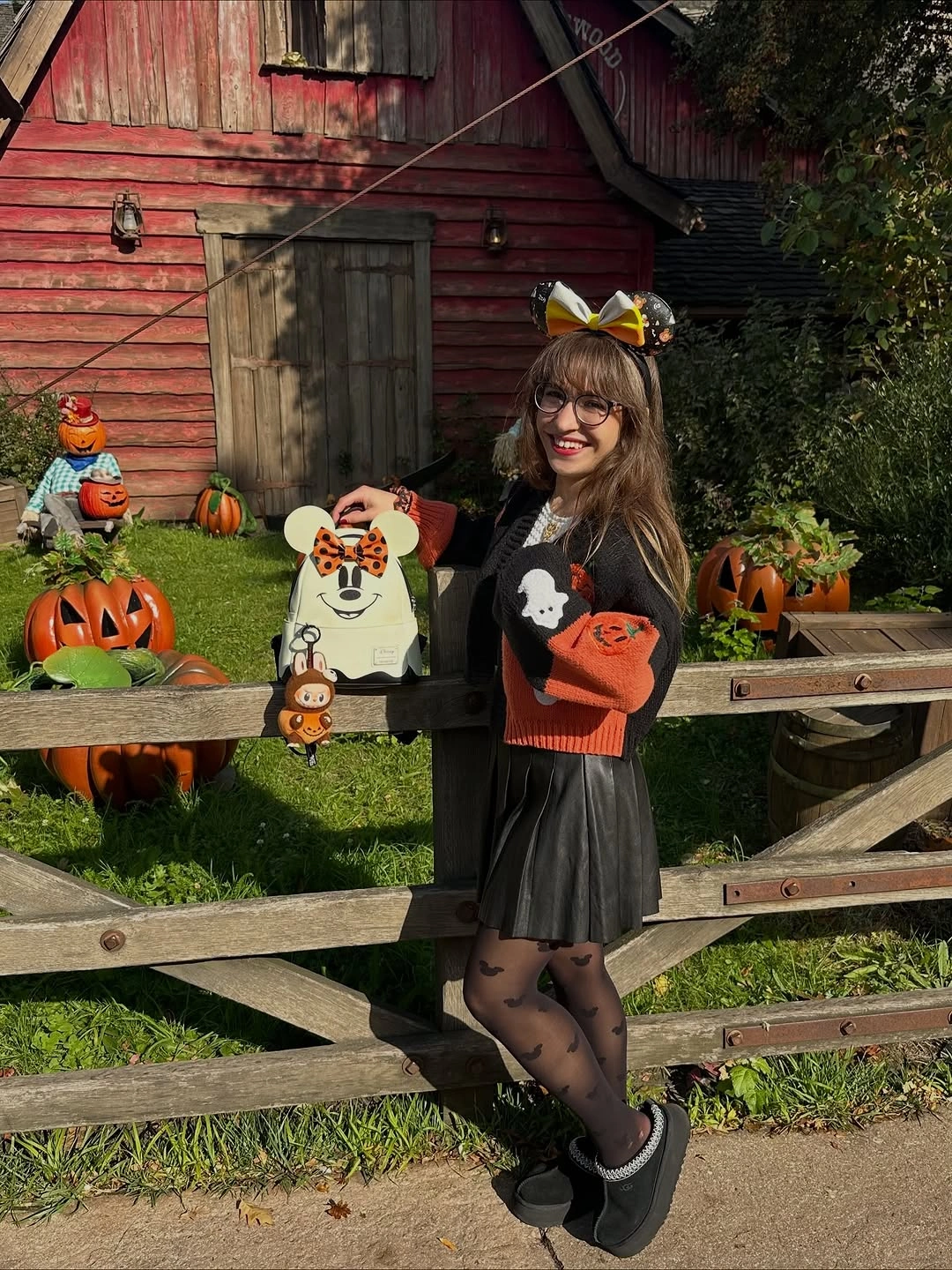 Black orange-graphic tee with pleated skirt cat-ear headband tights and dark shoes