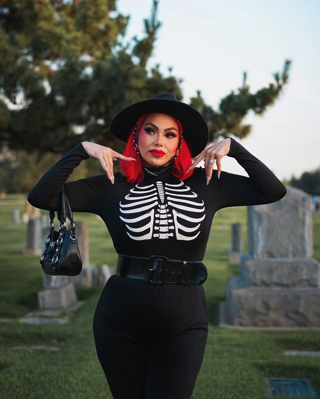 Black skeleton-print costume with wide-brim hat flared pants and dark gloves