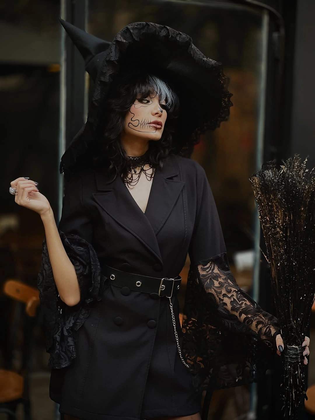 Black witch dress with lace sleeves wide-brim pointed hat waist belt and dark makeup