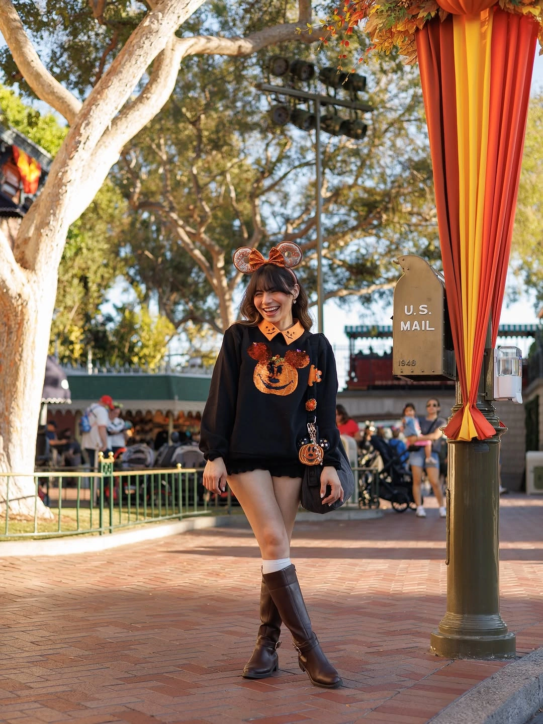 Black Halloween motif sweater with short black skirt and tall dark boots