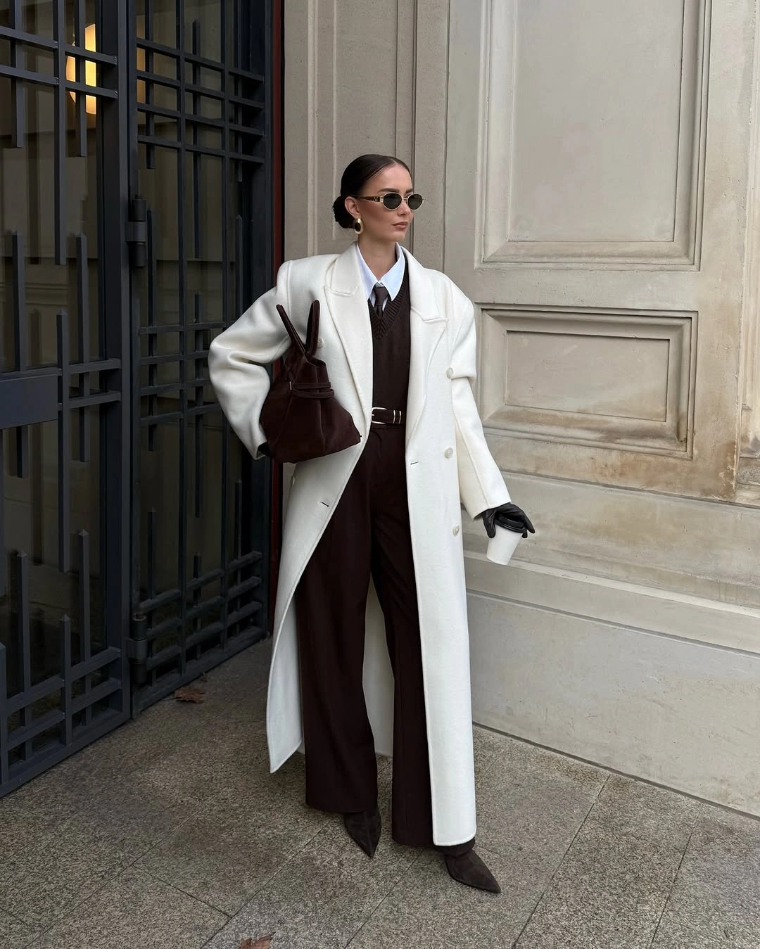 White long coat with dark brown trousers and burgundy bag for work