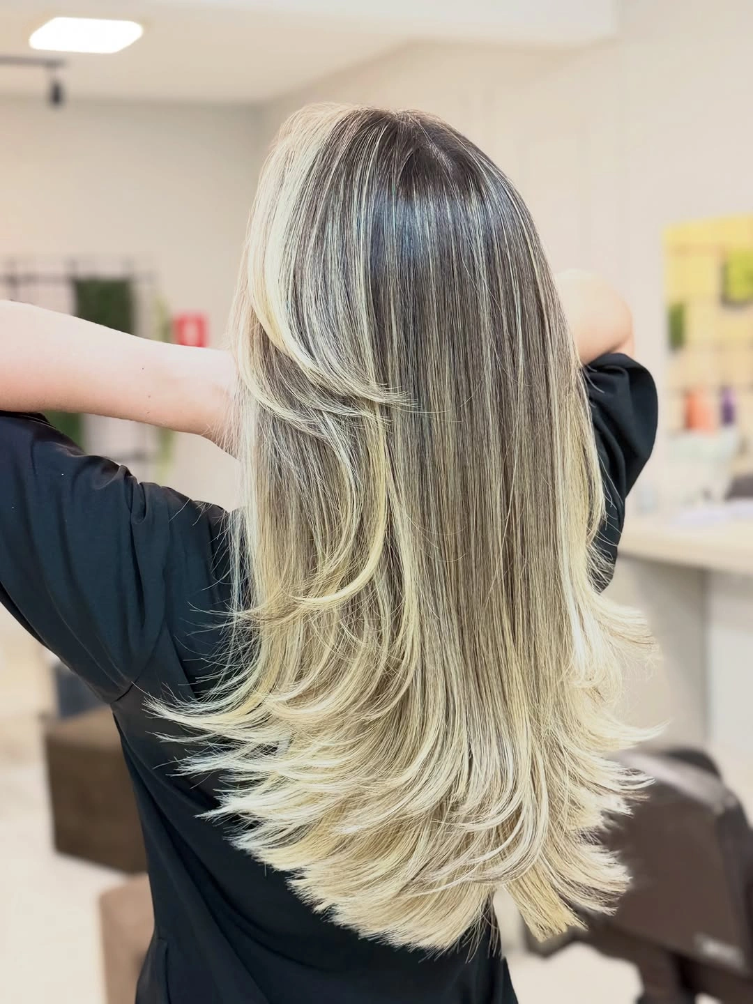 Long layered blonde hair with darker roots and lighter ribbons