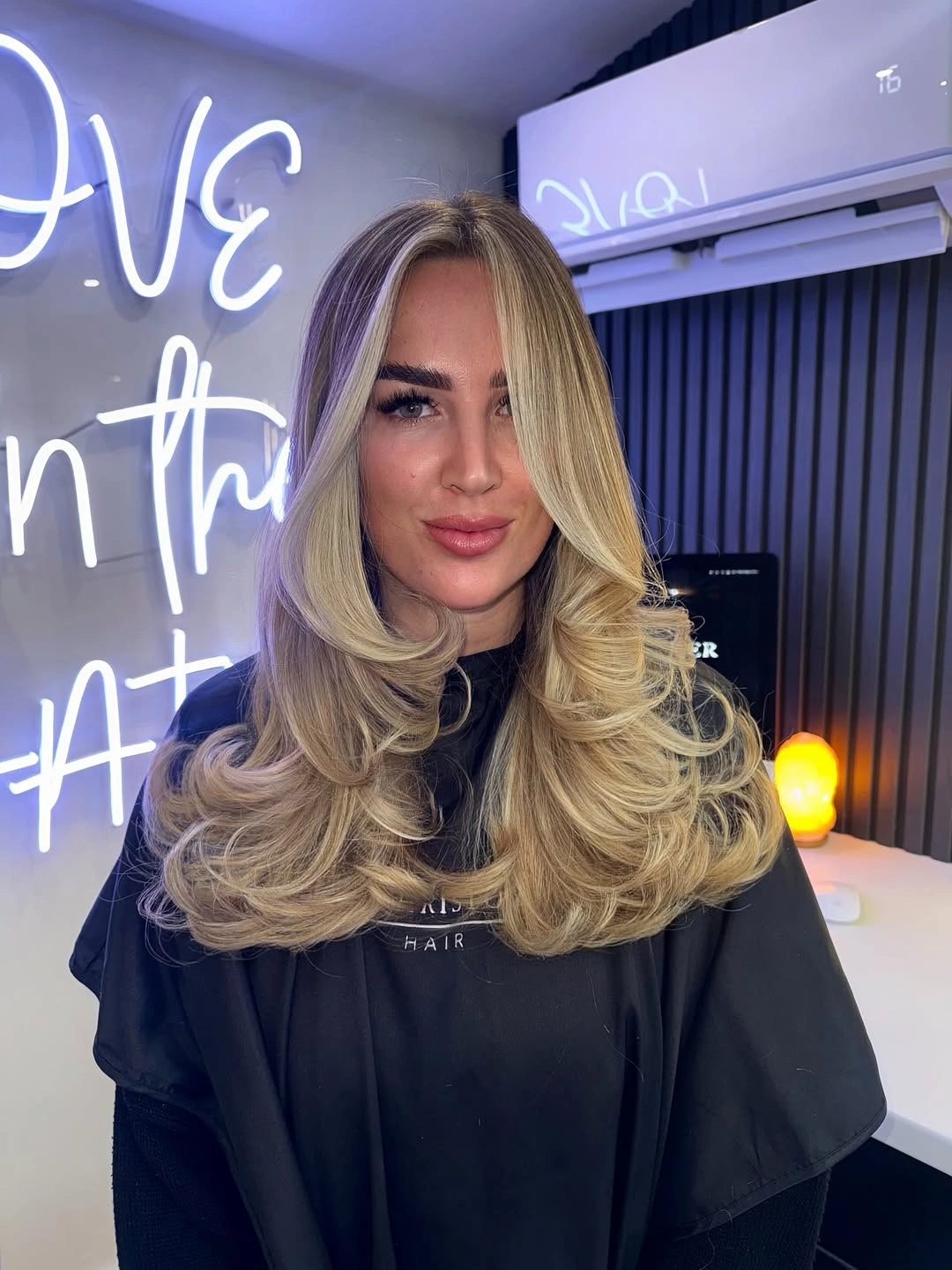 Long beige blonde hair with bouncy curled face-framing layers