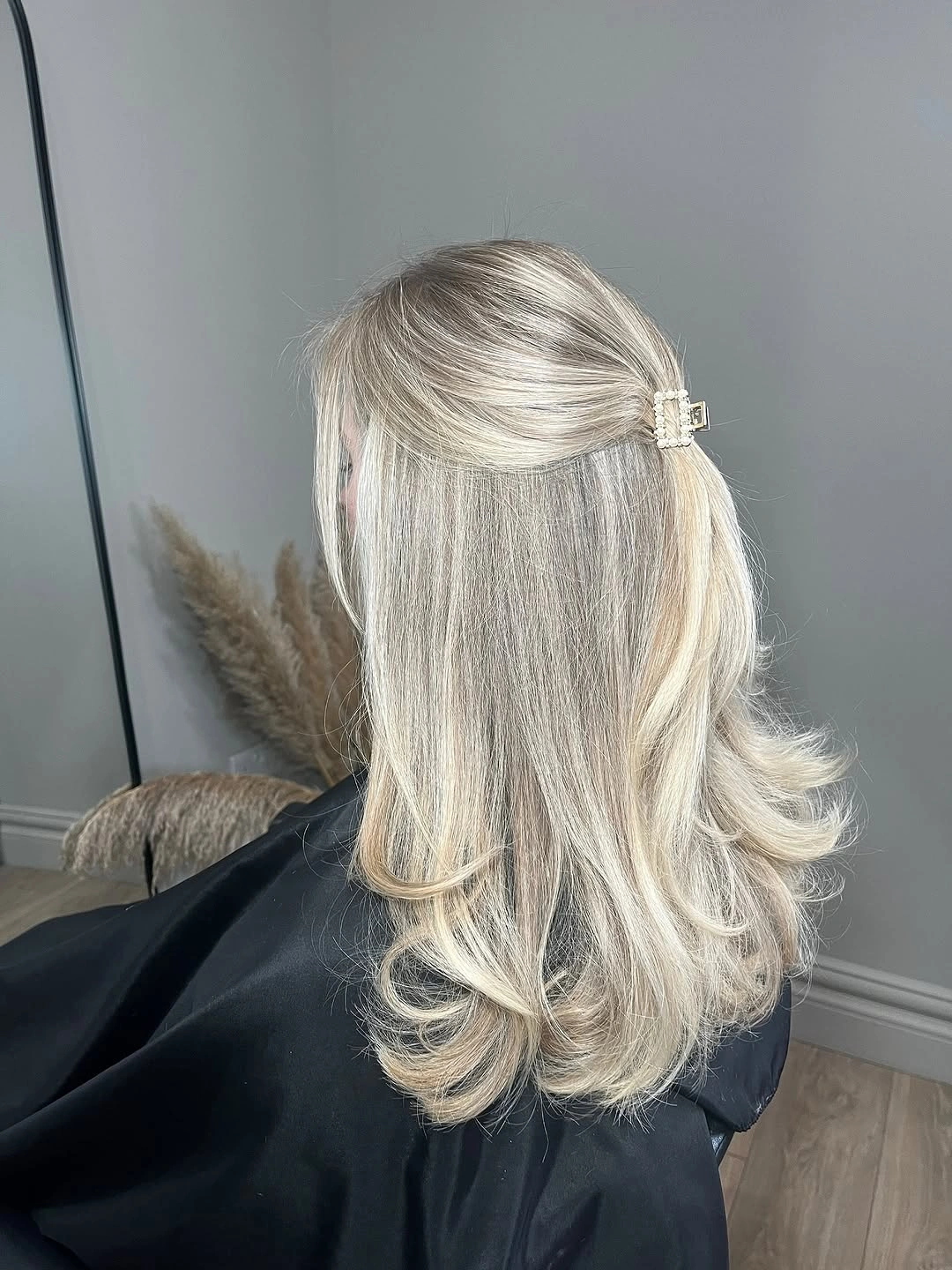 Medium blonde hair with clipped half-up section and flipped ends