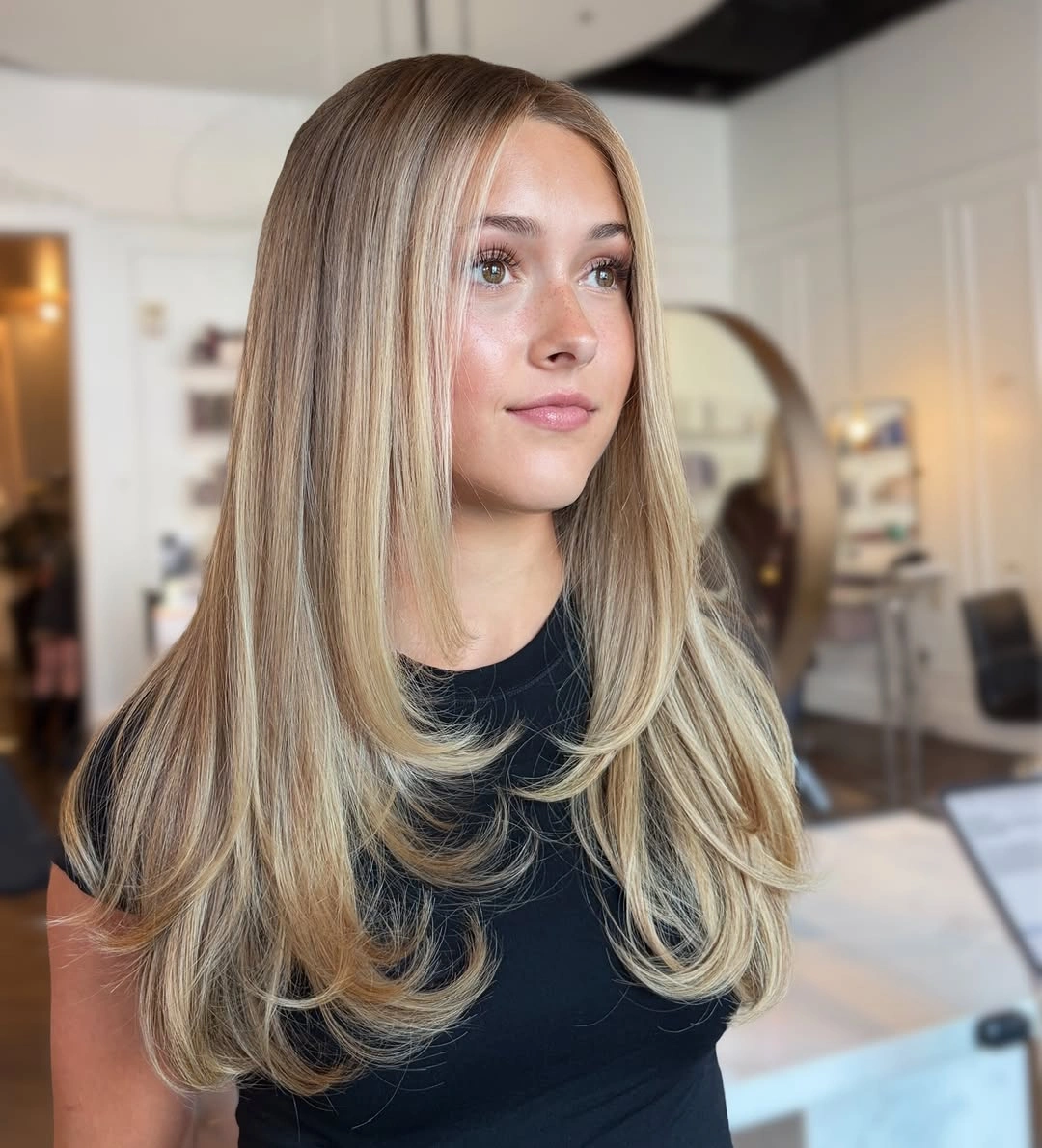 Beige blonde hair with long curved face-framing layers