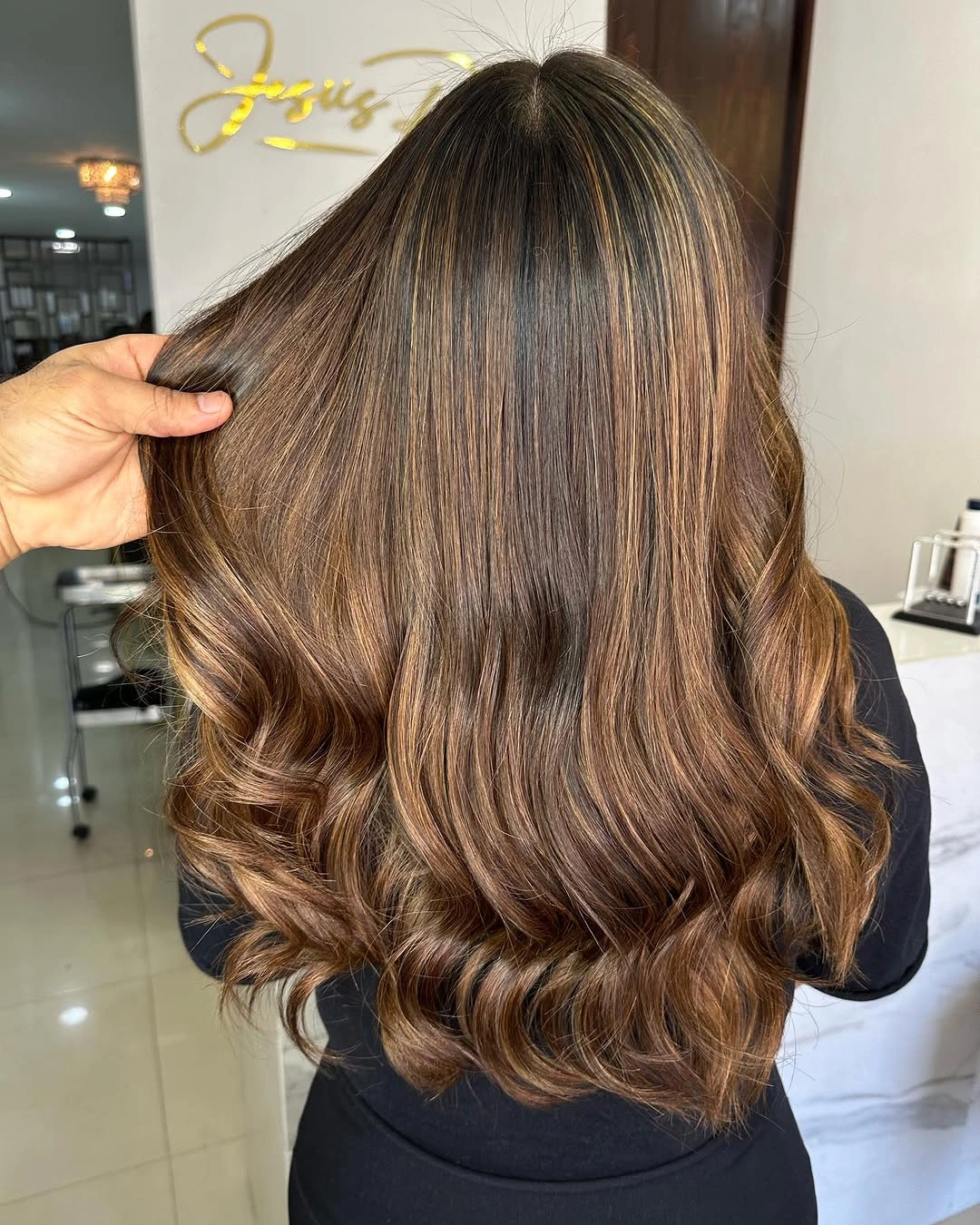 Long brunette hair with fine caramel ribbons and warm curled ends