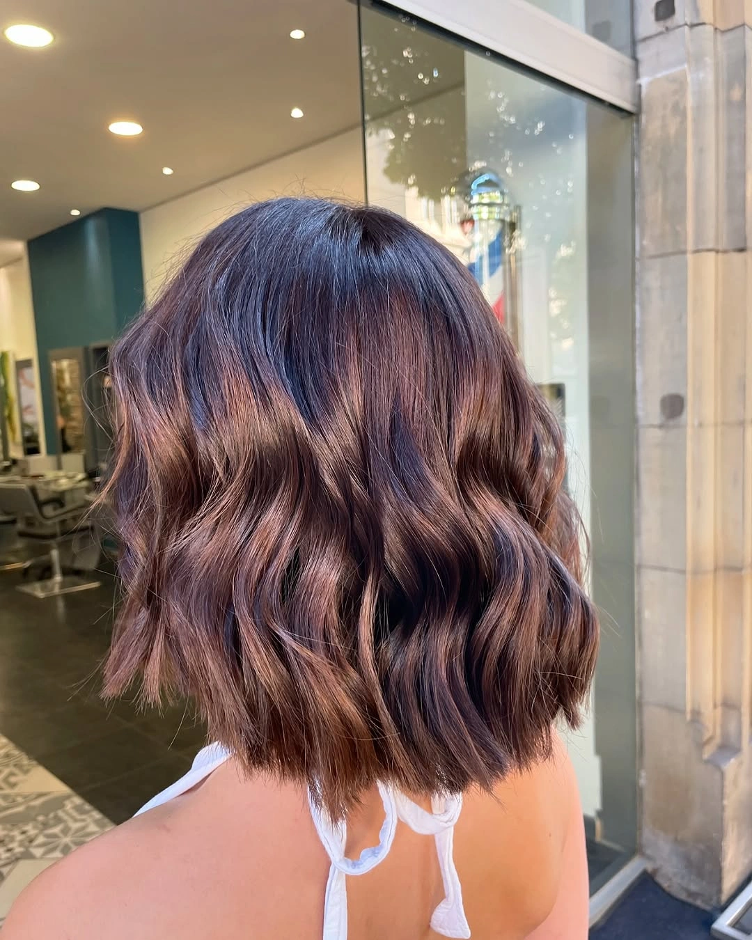 Short wavy brunette lob with plum-burgundy warmth