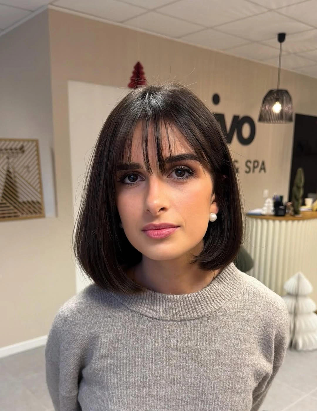 Short dark brunette bob with wispy bangs and curved ends