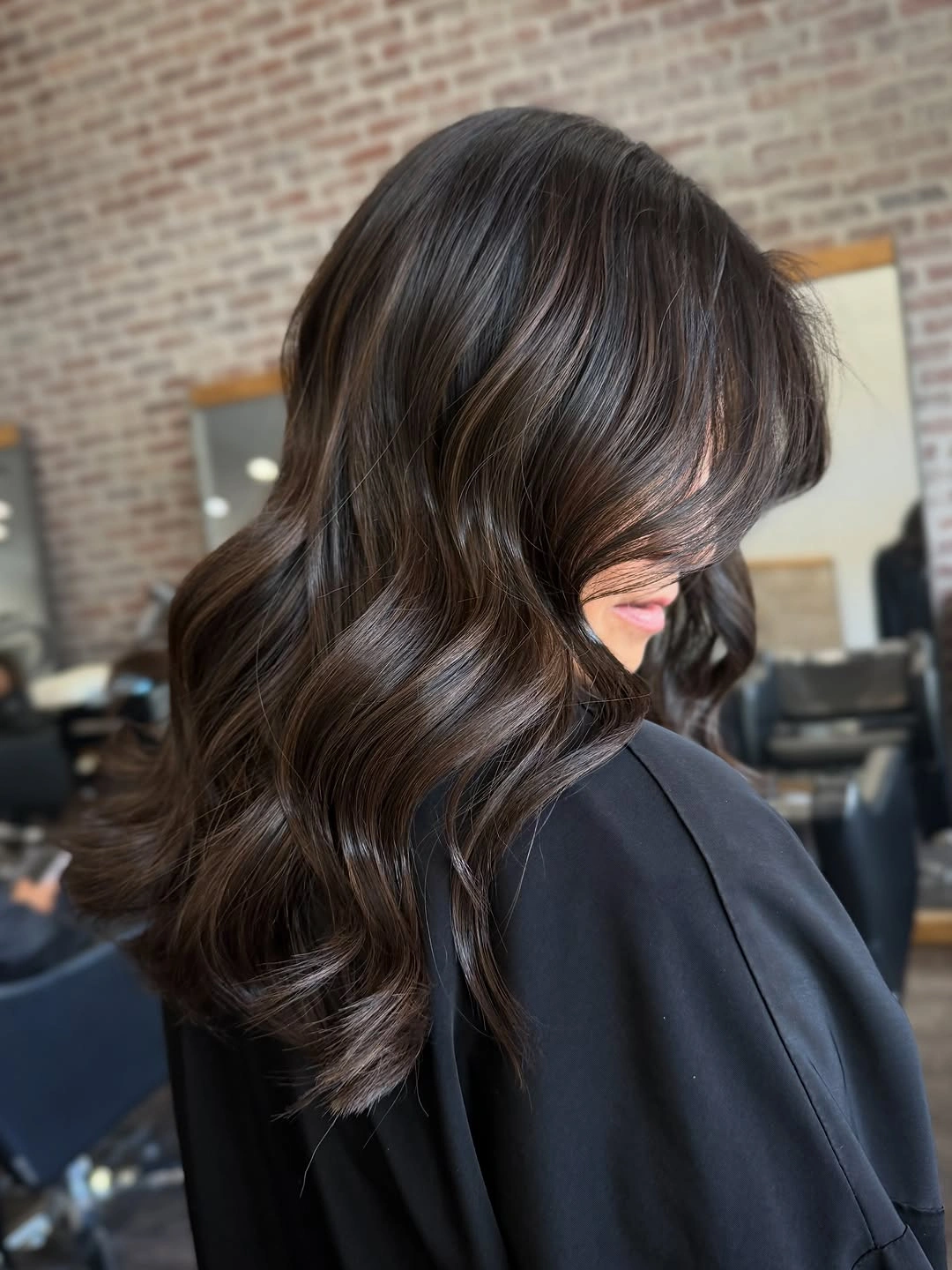 Medium dark brunette waves with long curtain fringe and chocolate shine