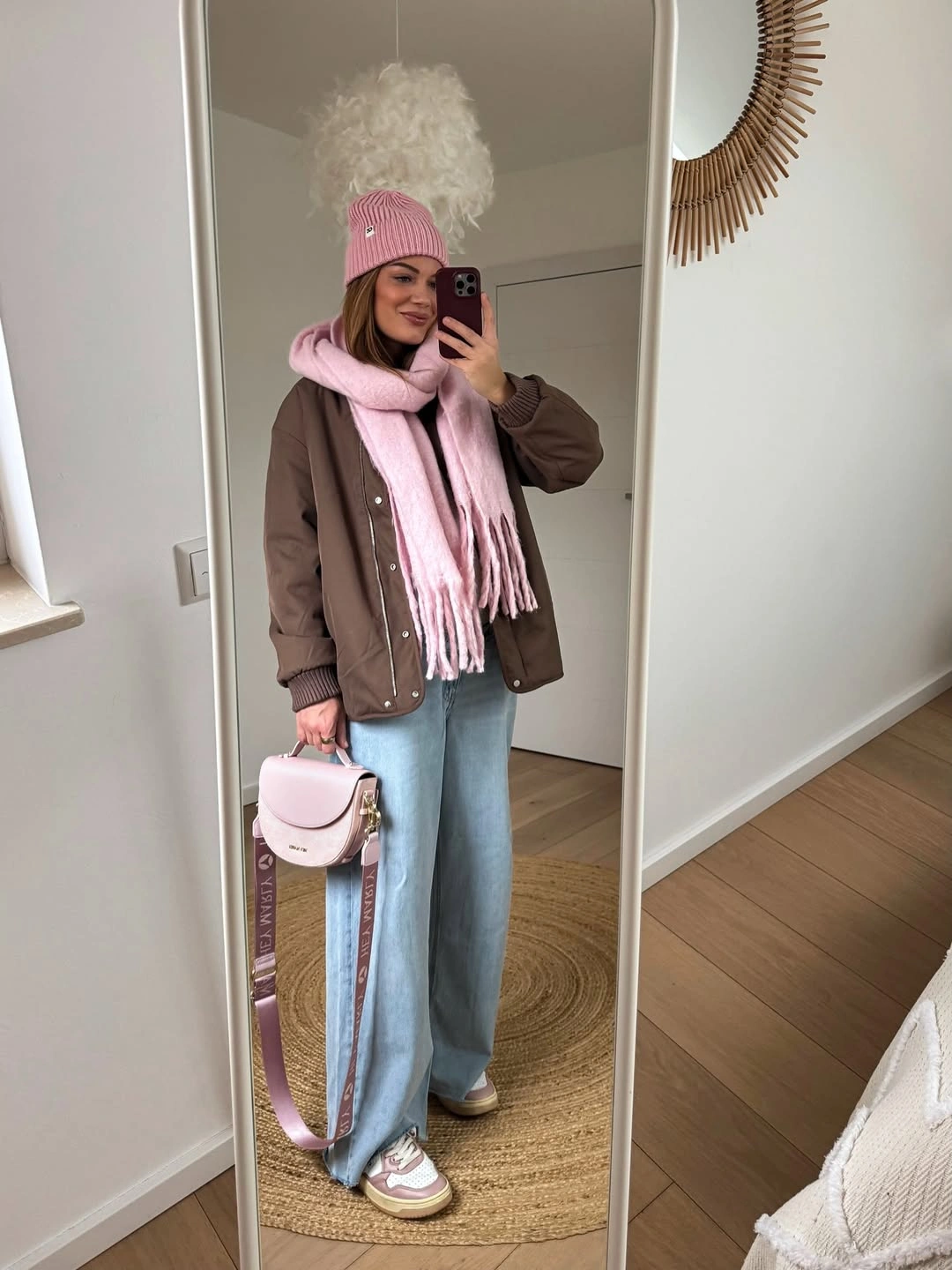 Brown jacket with pink scarf beanie bag and pale wide jeans