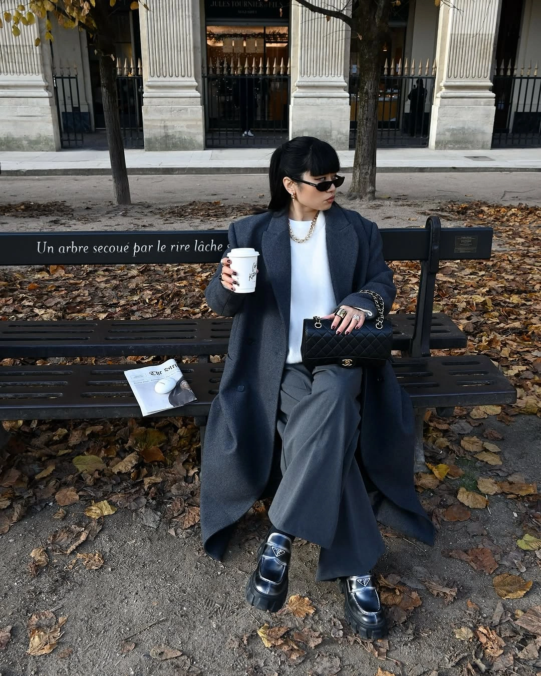Long charcoal coat white top gray trousers and black loafers
