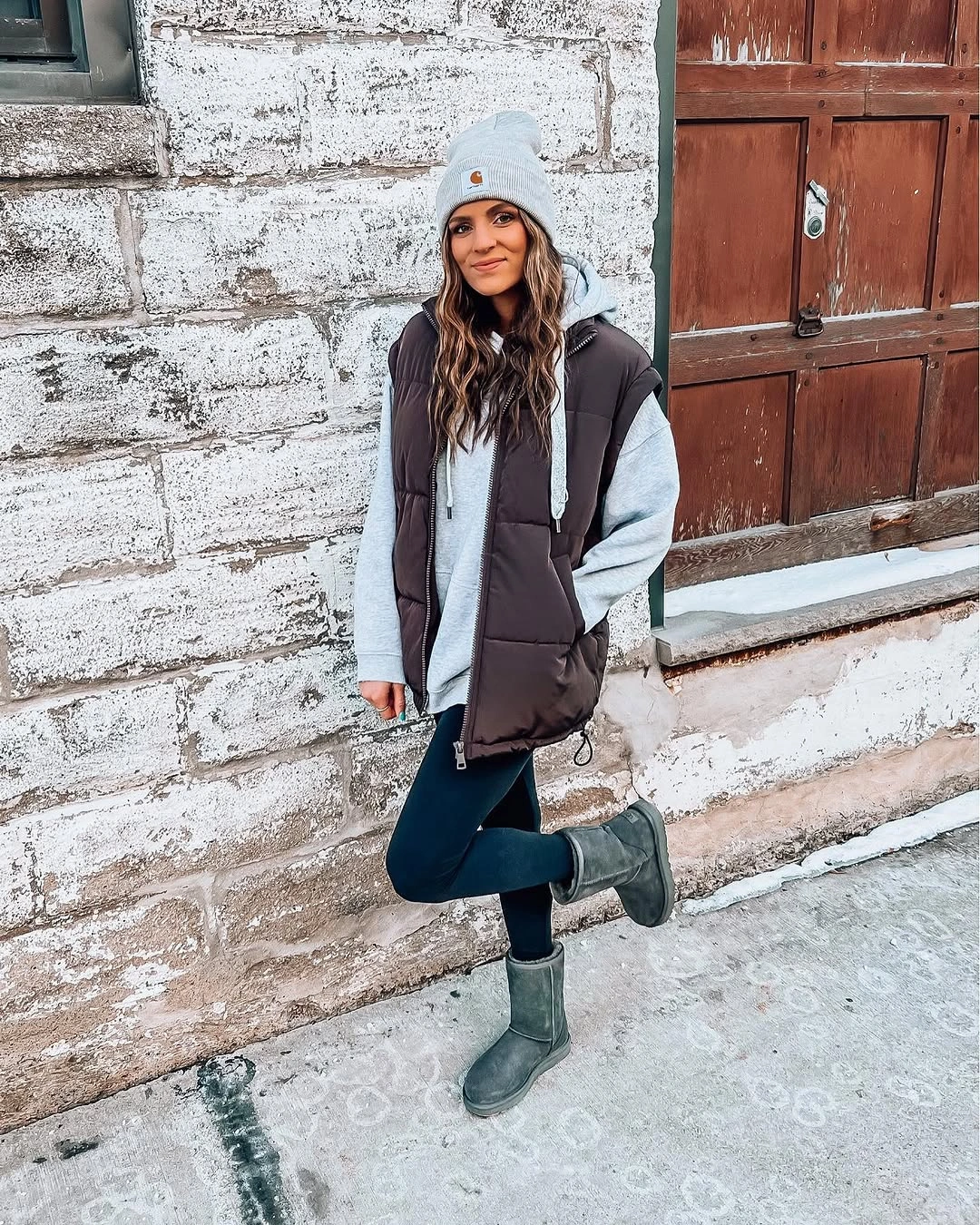Gray hoodie brown quilted vest black leggings and blue beanie
