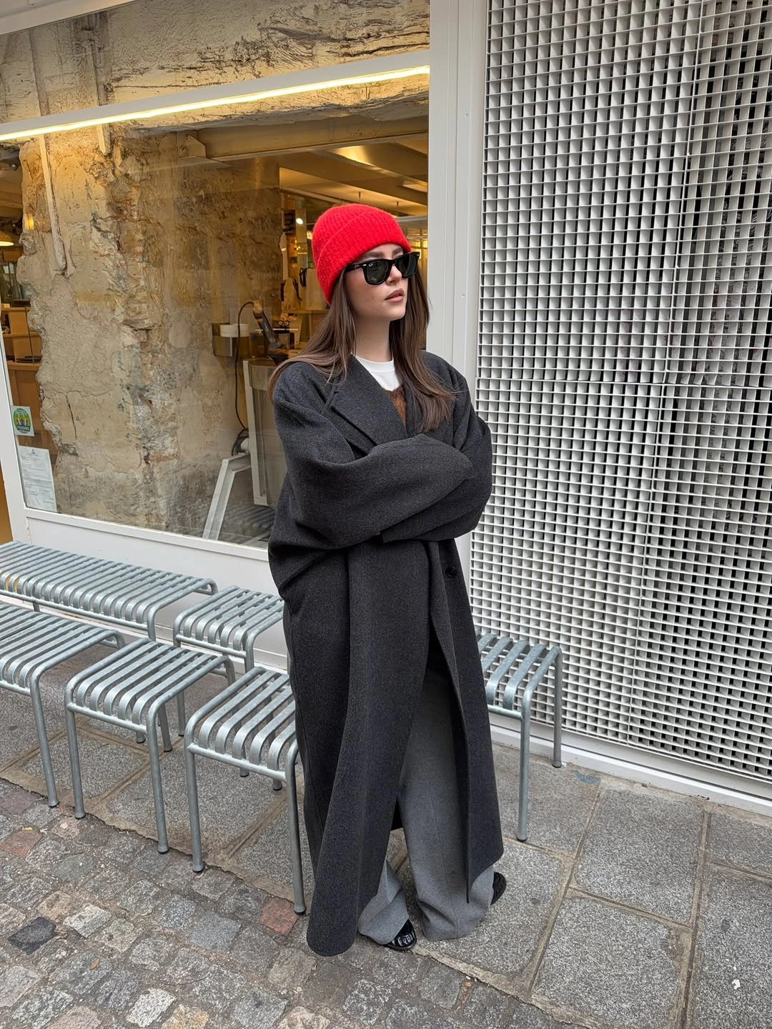 Long charcoal coat gray wide trousers and red beanie