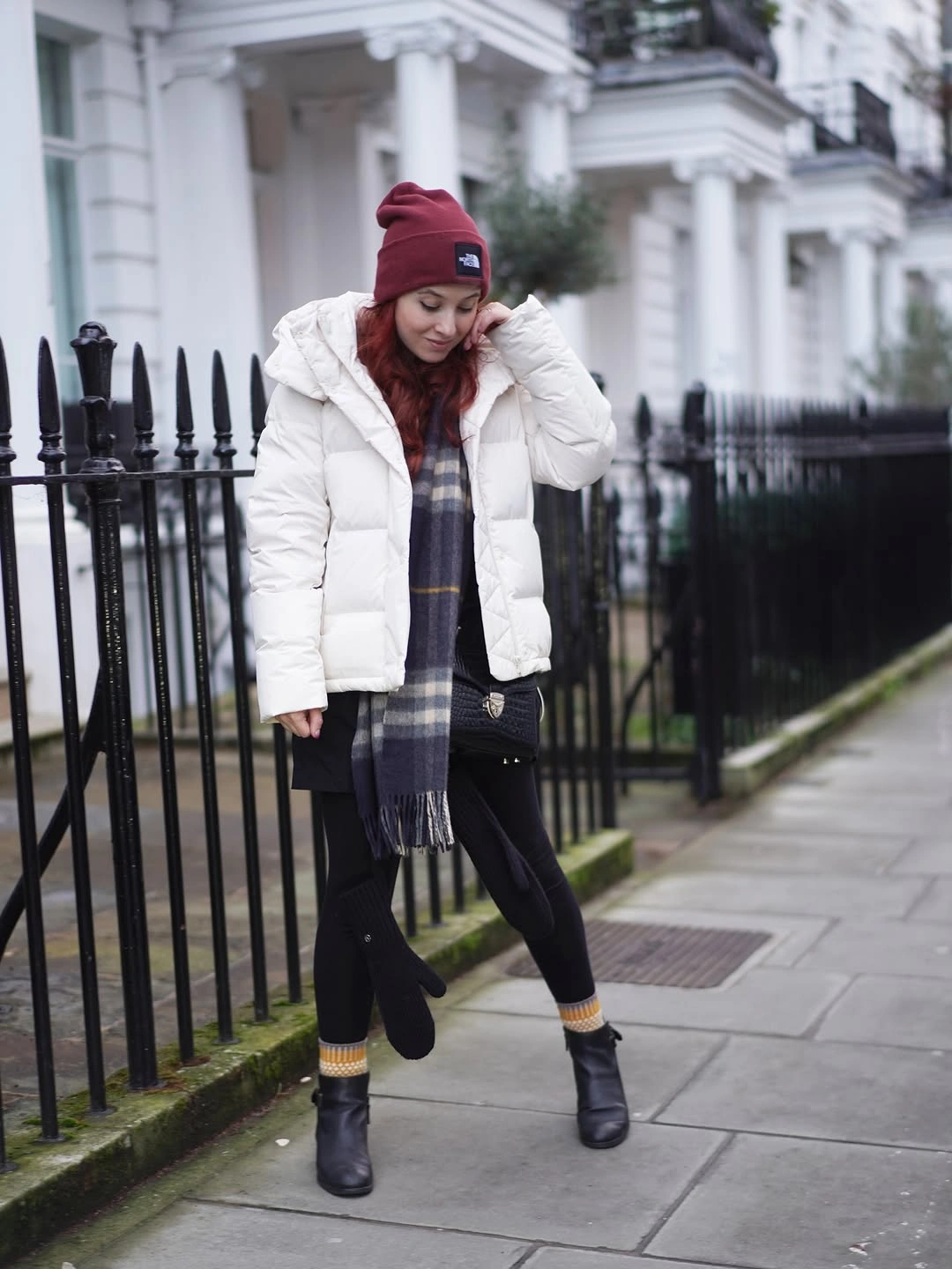 Black coat, neutral knit, light blue jeans, and black boots