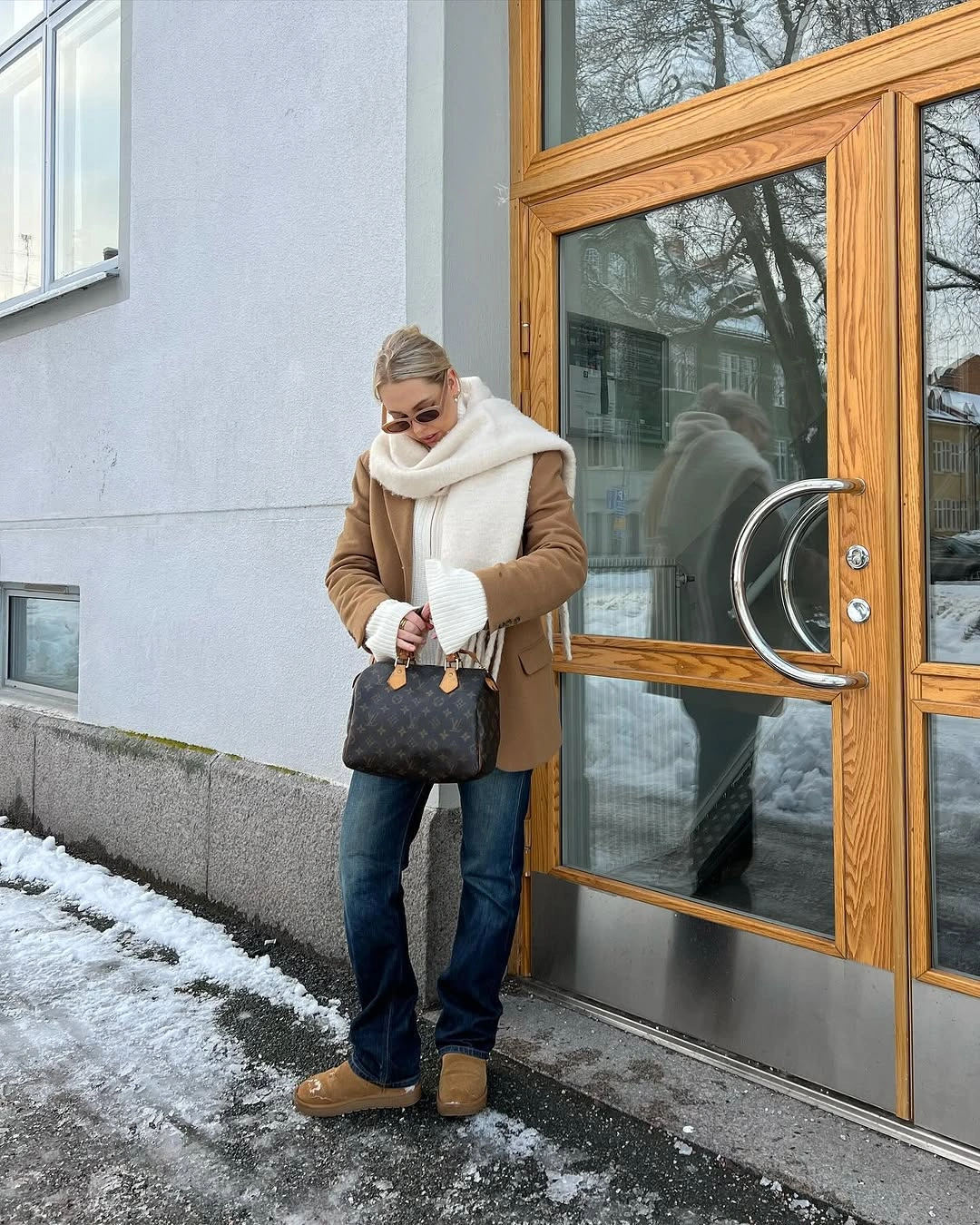 Tan jacket, cream scarf, dark blue jeans, tan shoes, patterned handbag