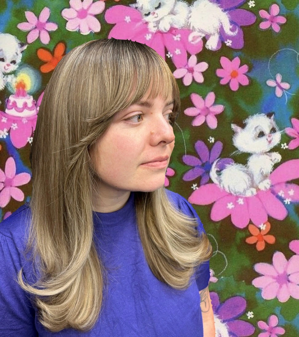 Long blonde layered haircut with full bangs and flipped ends