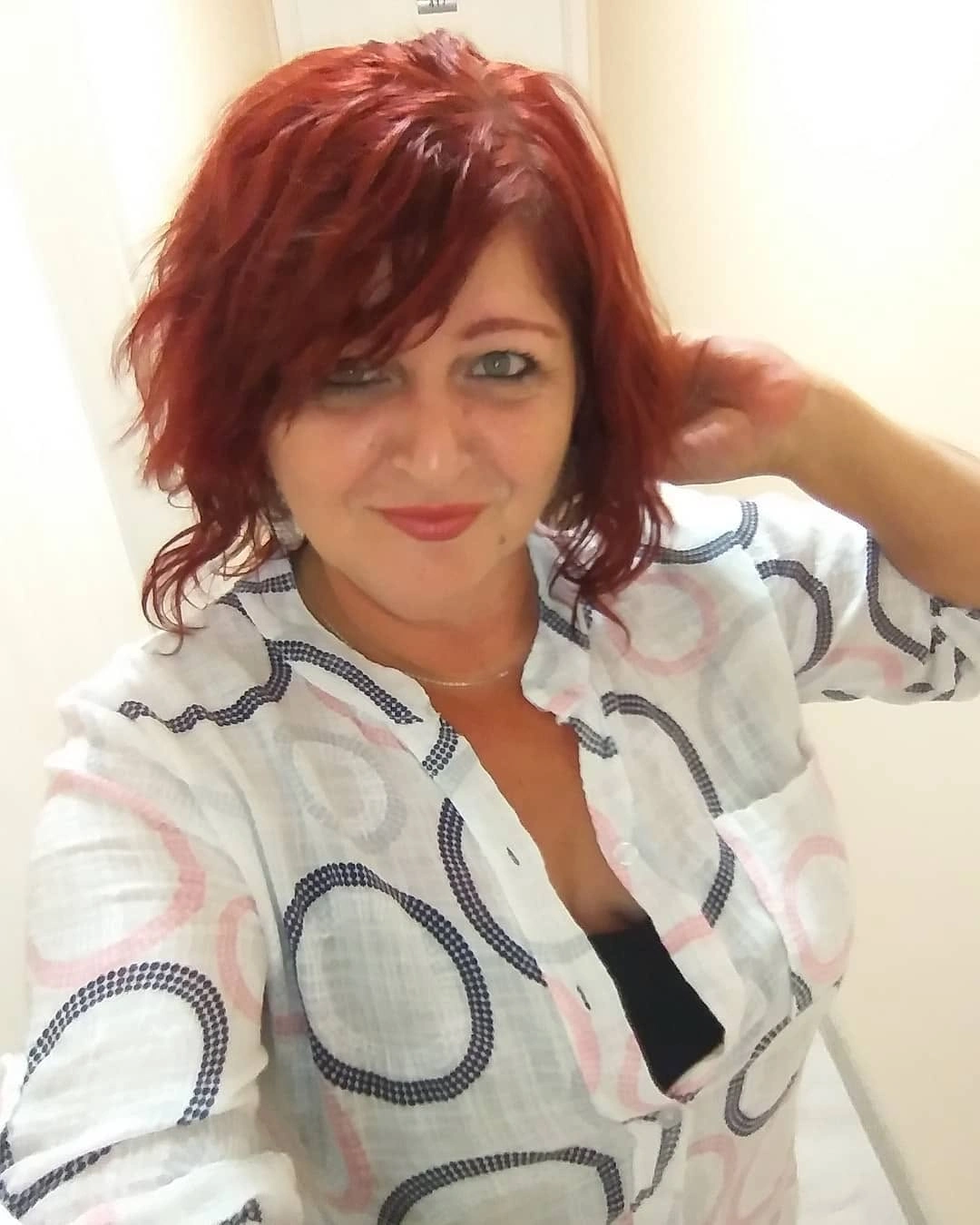 Short red wavy haircut with side-swept bangs