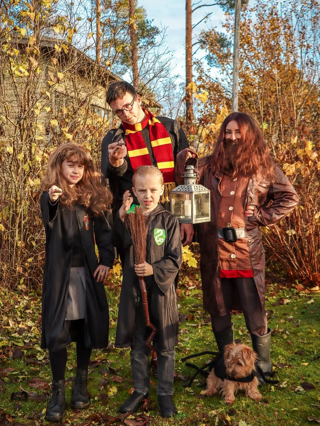 Family in dark wizard-school inspired robes with striped scarf