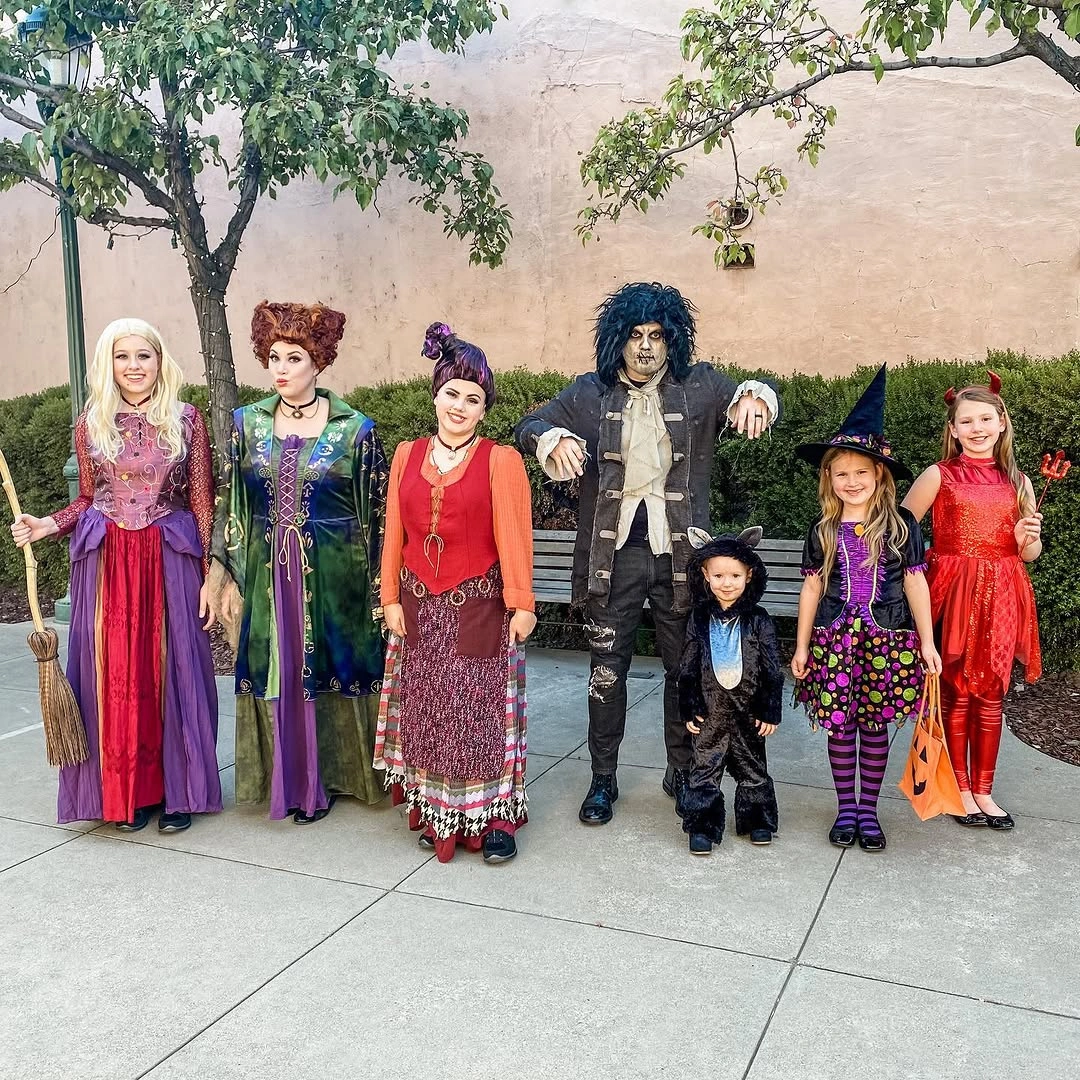 Family in layered witch and fortune-teller Halloween costumes