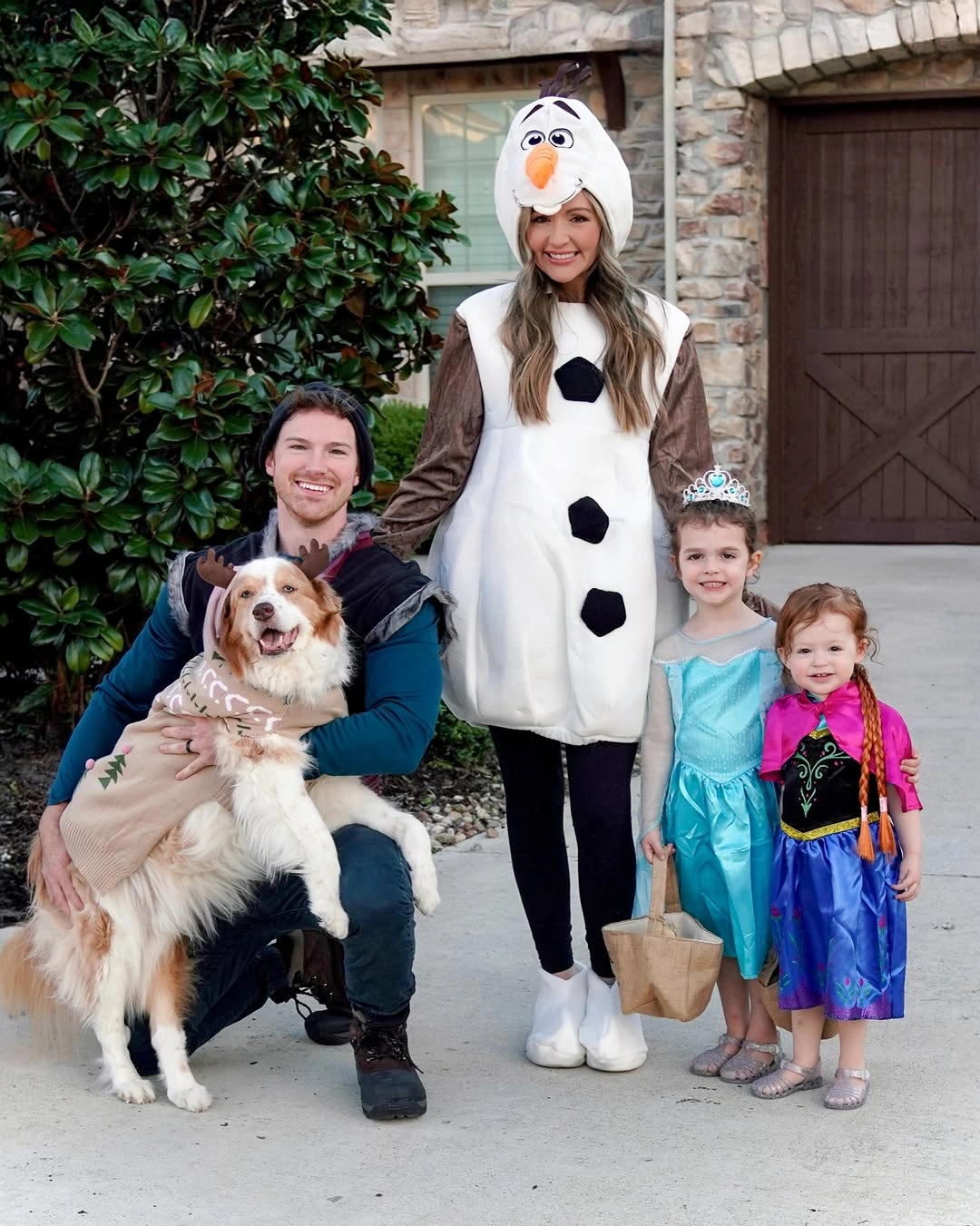 Family in snowman and blue purple princess-inspired costumes with dog