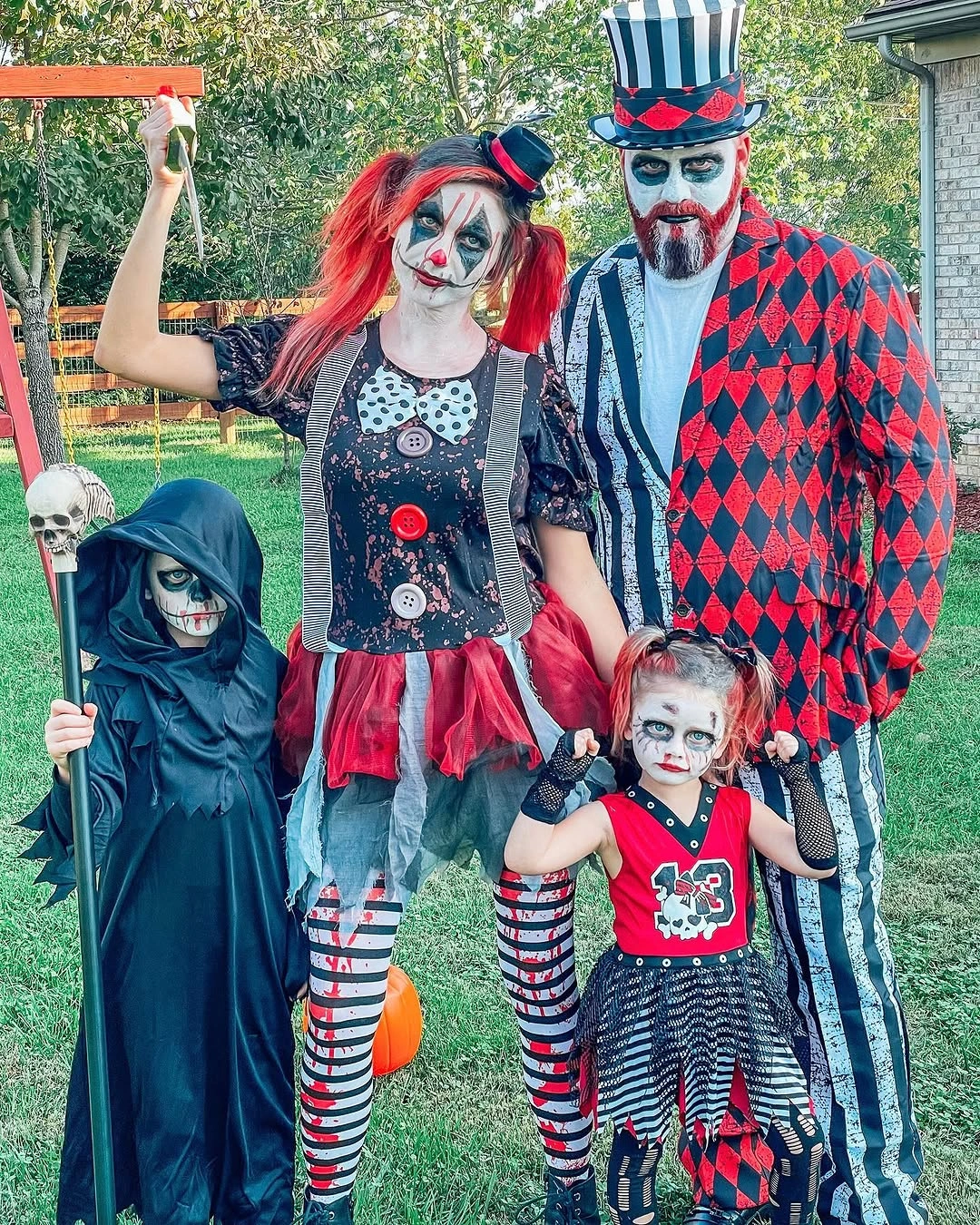 Family in theatrical spooky costumes with face makeup and stripes