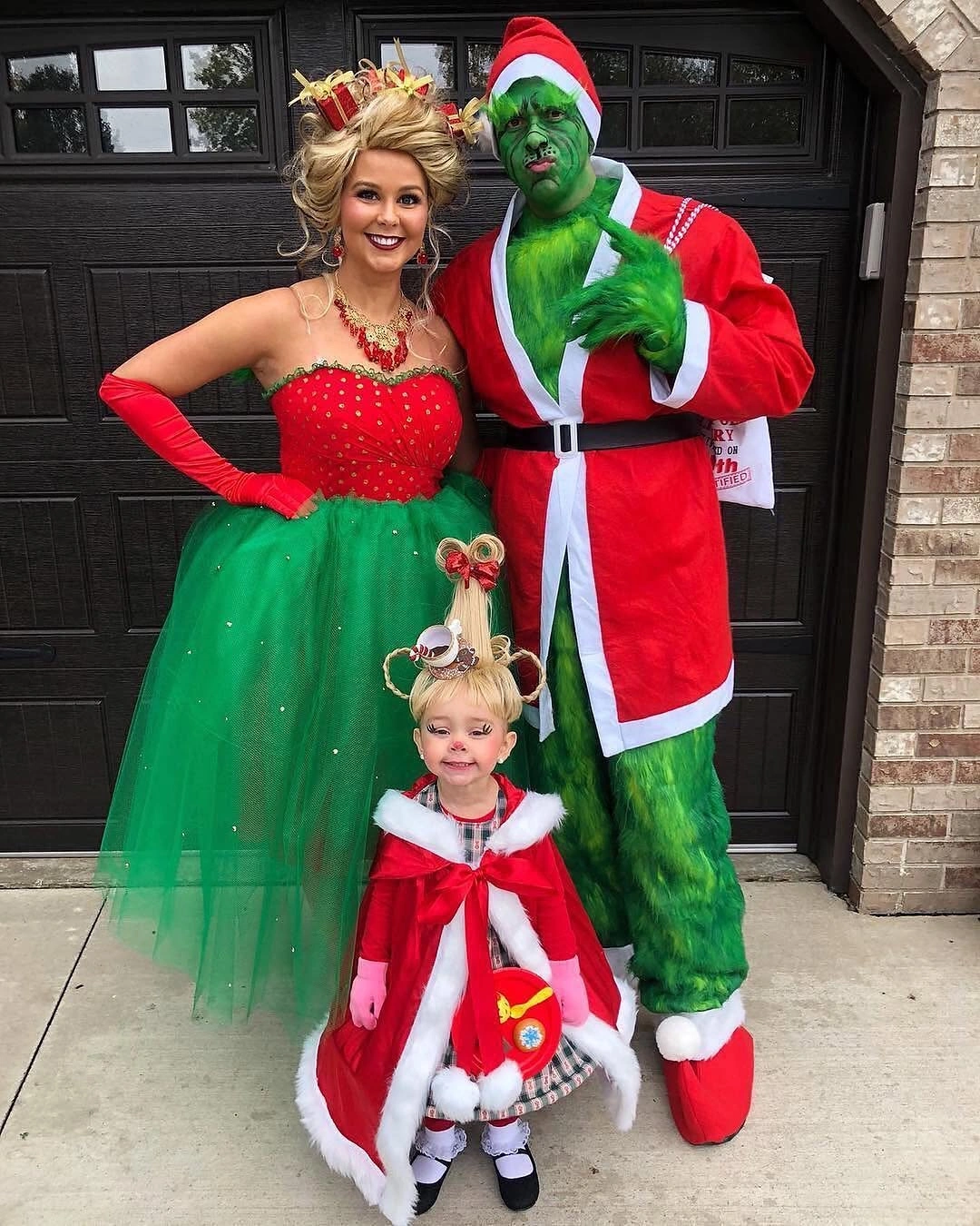 Family in red green holiday character costumes with child
