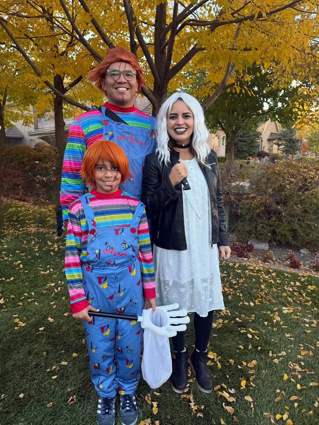 Family in orange-haired striped and blue overall character costumes