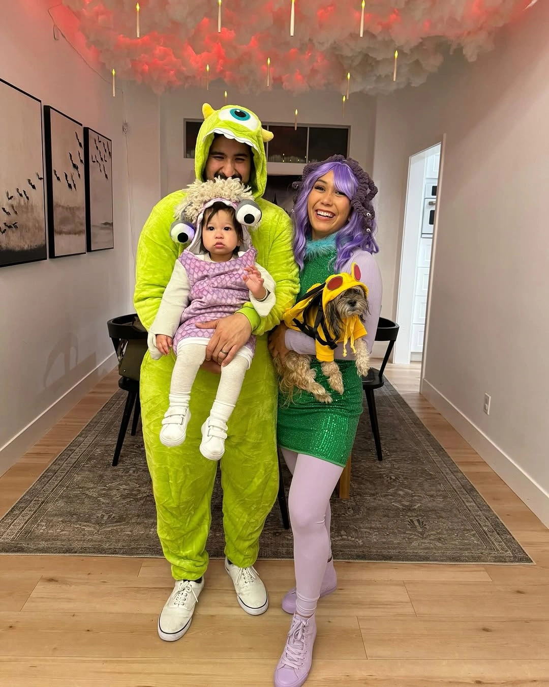 Family in lime monster and green costumes with baby and dogs