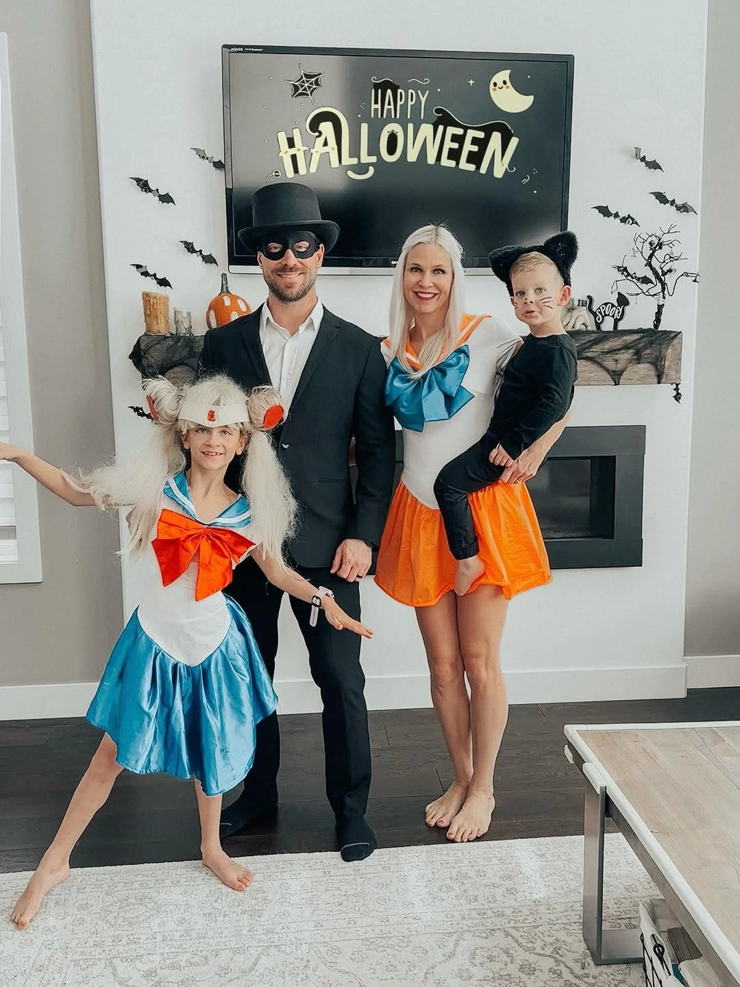 Family costumes in black white orange and blue indoors