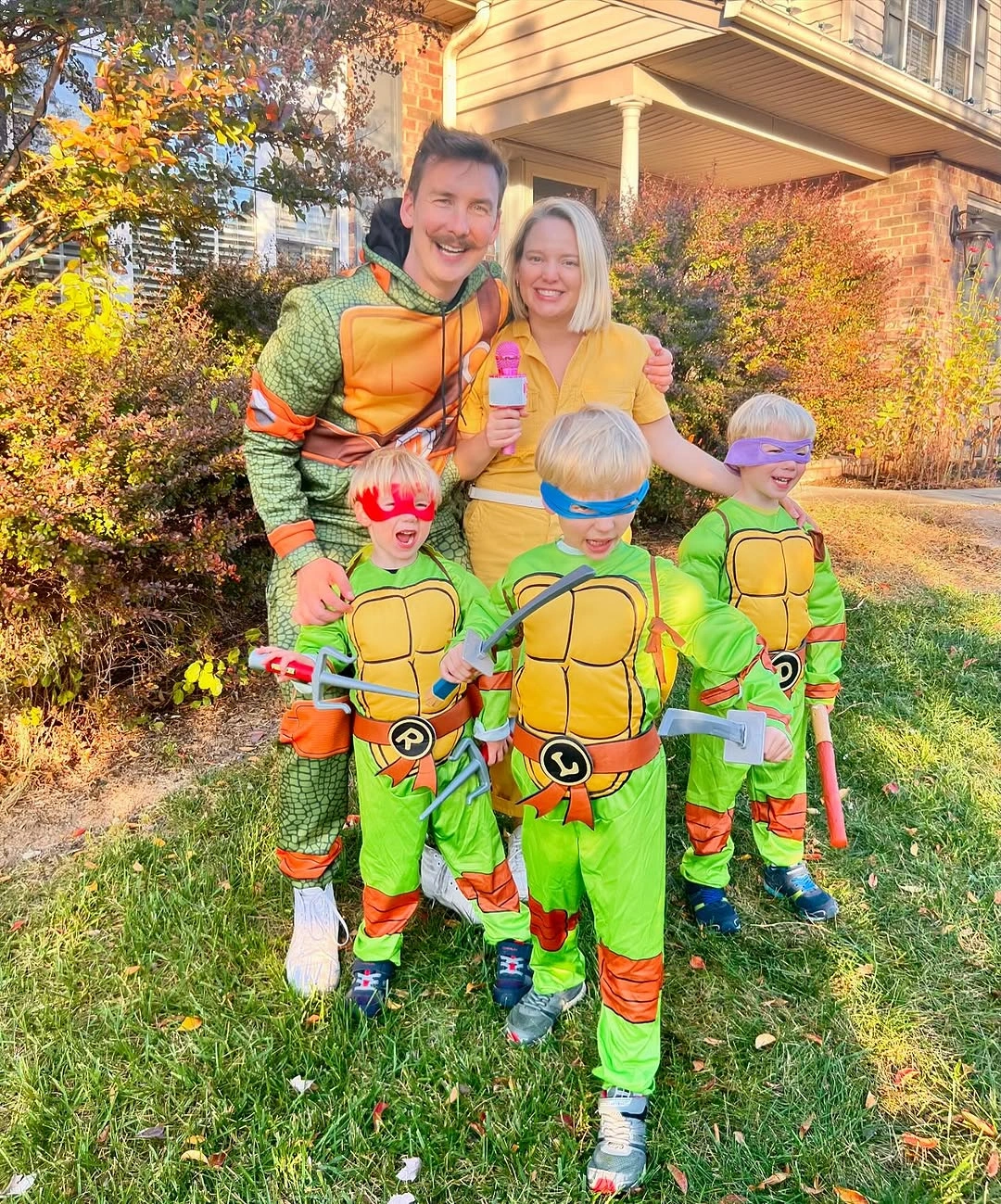 Family in bright green turtle costumes with colored eye masks