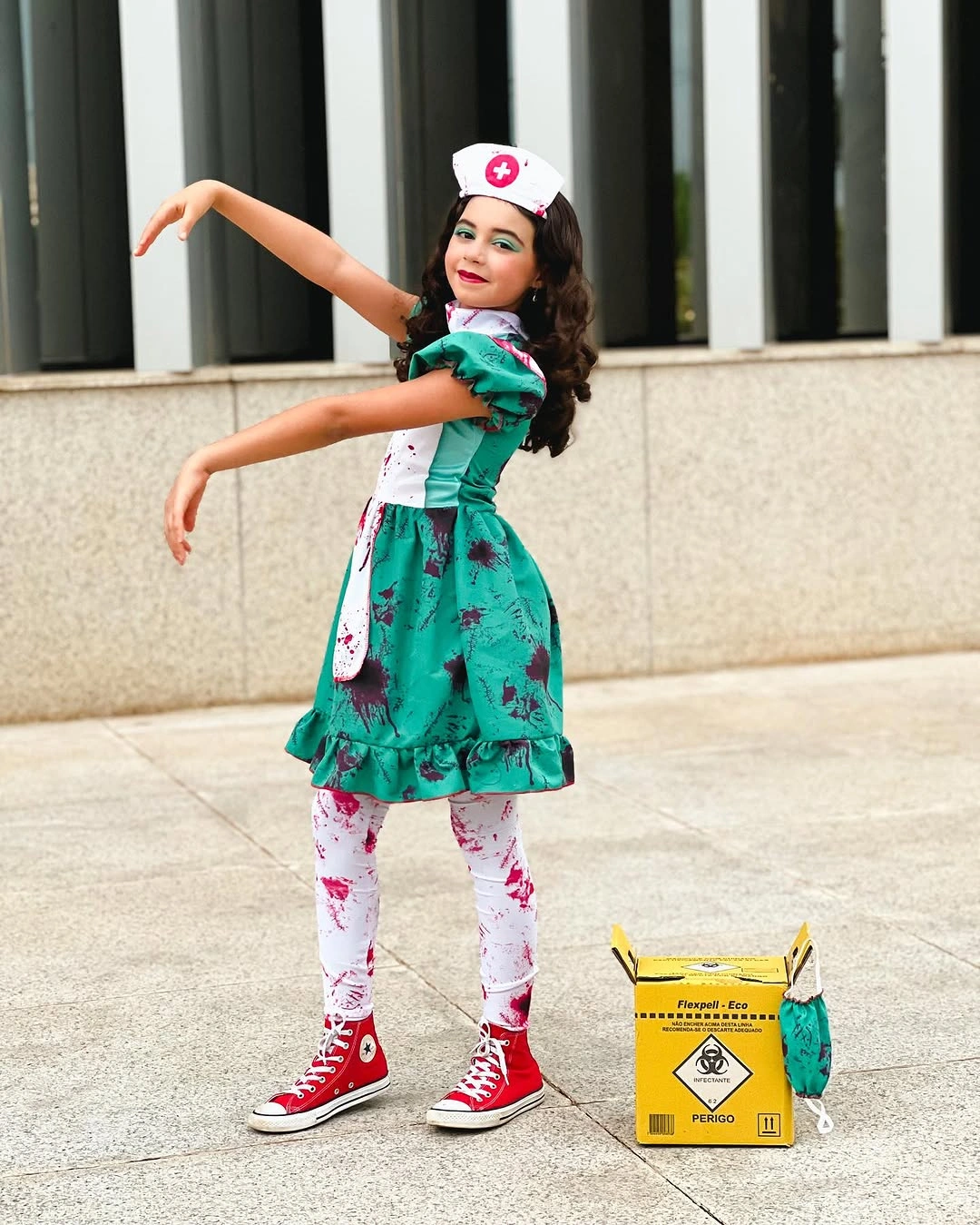 Girl in green nurse dress with red sneakers and cap