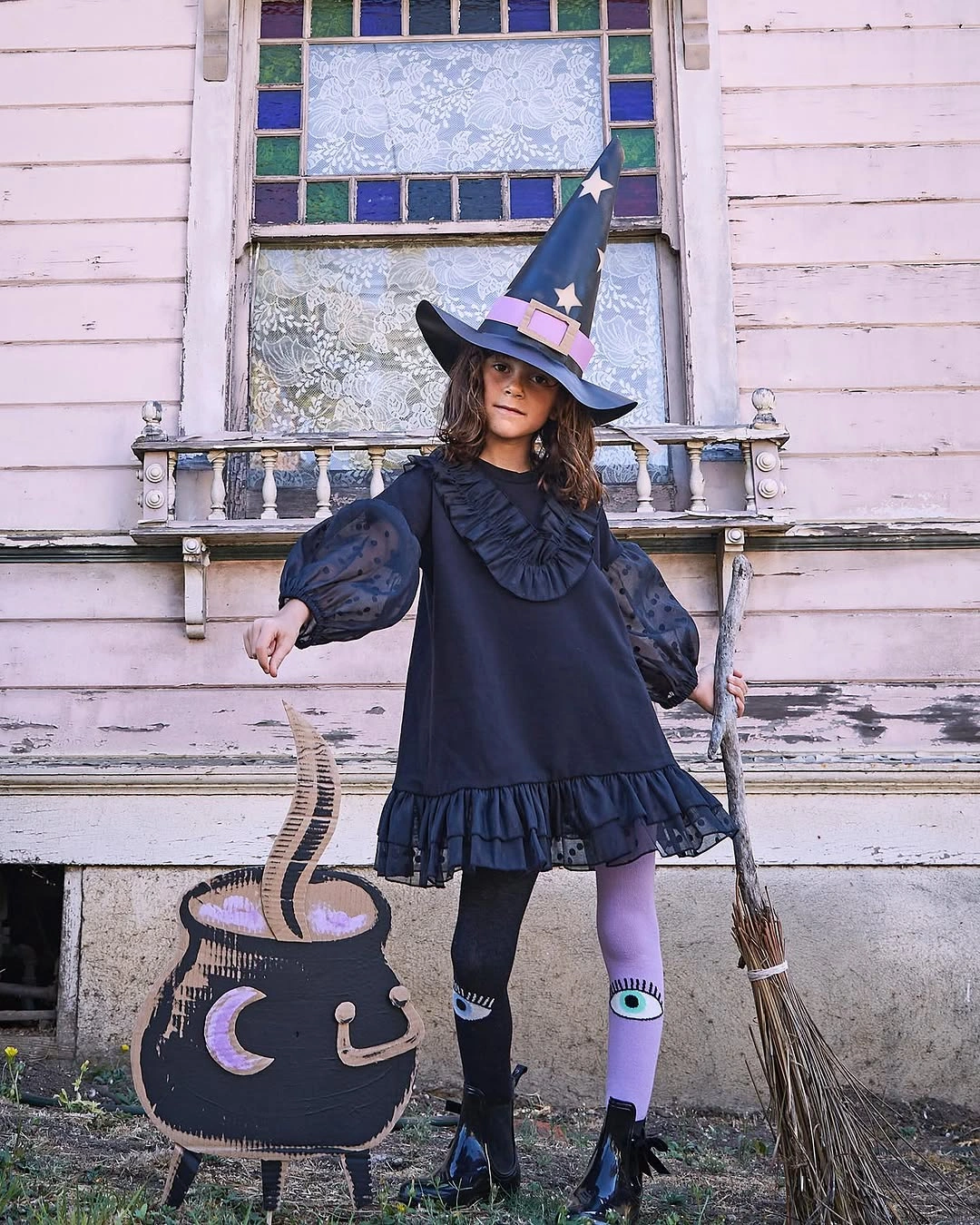 Girl in deep blue witch dress with lavender-trimmed hat