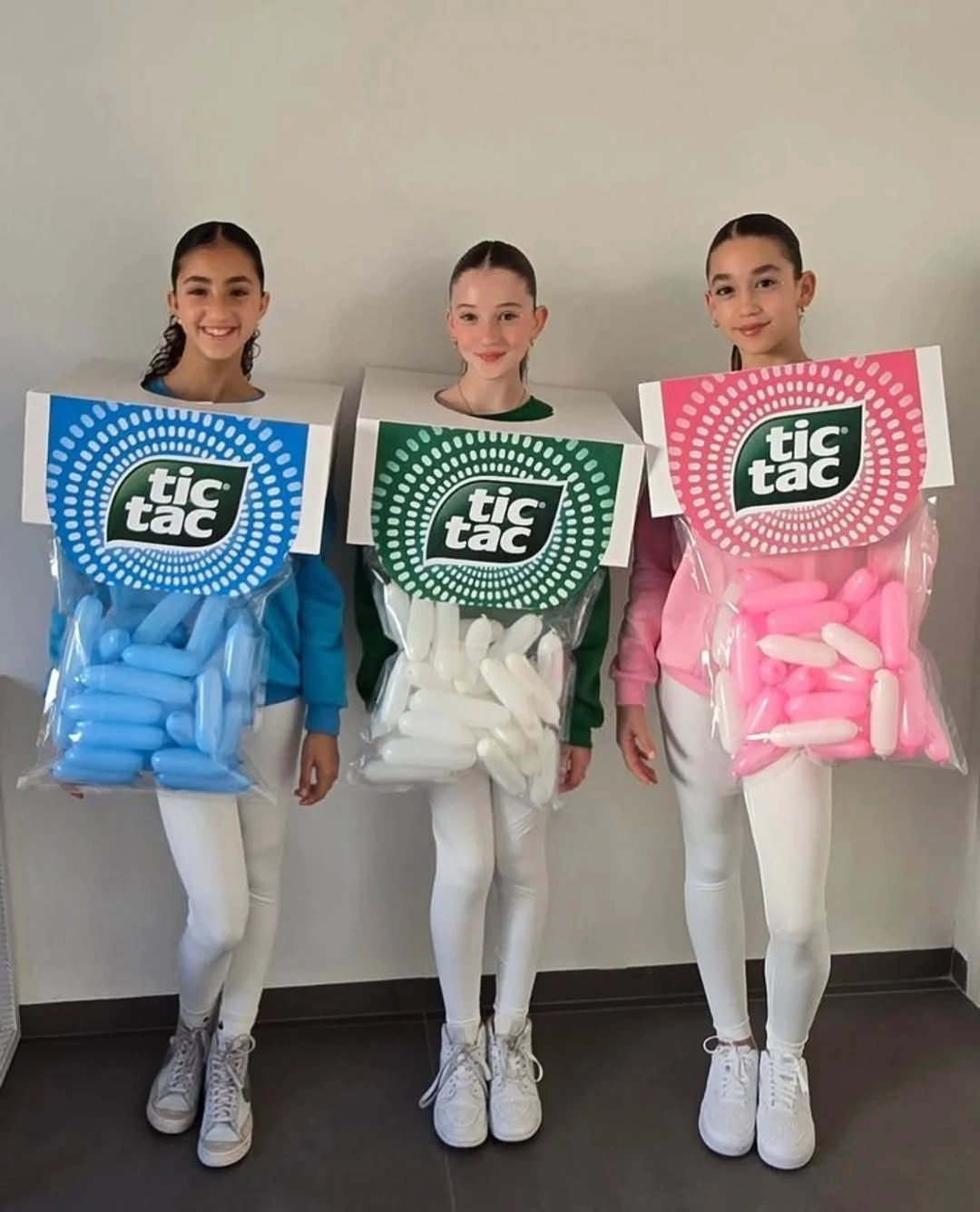 Three girls in blue green and pink tic-tac box costumes